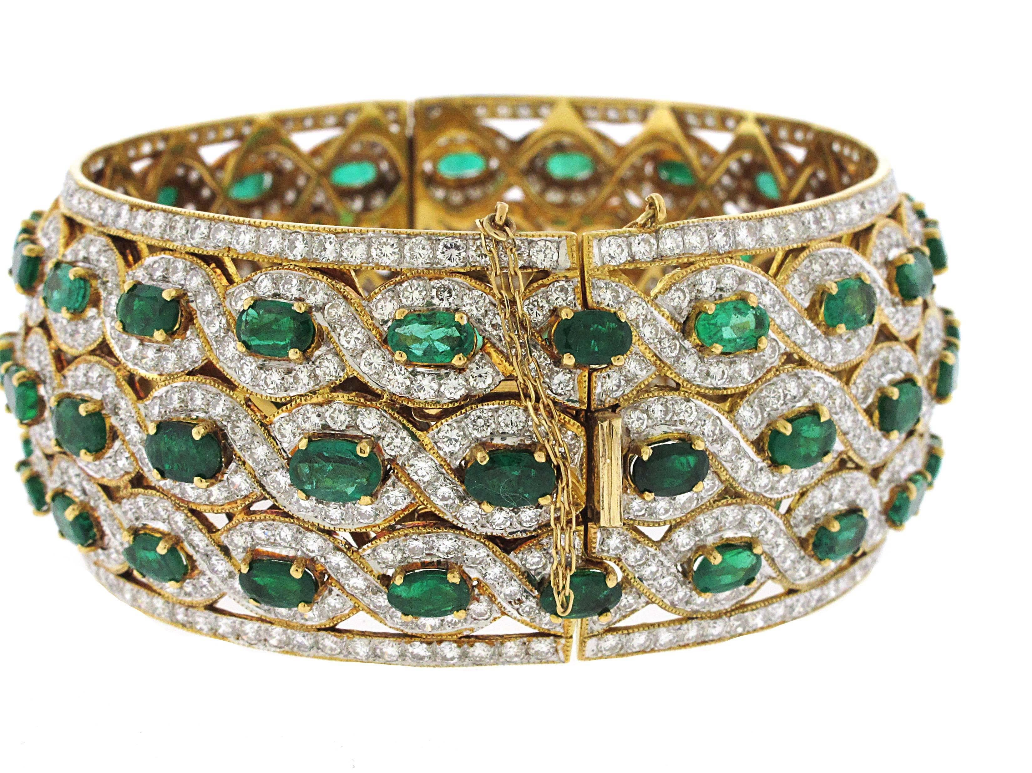 Gorgeous one of a kind emerald and diamond bangle. We approximate 15.50 carats of green emeralds and over 14 carats of white diamonds. This is set in 20kt yellow gold, not 14kt or 18kt making it an extremely well made bangle bracelet. Will fit a