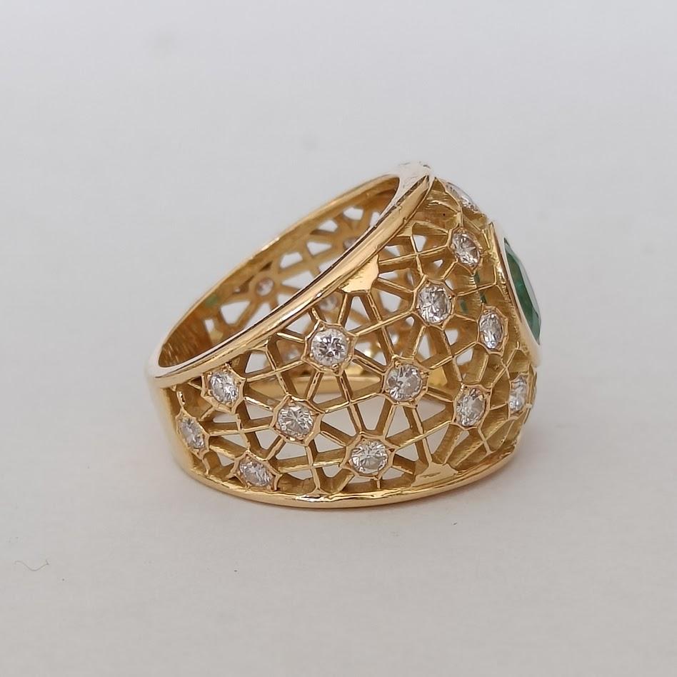 L'anello a forma di cupola mostra un motivo a rete ornato da diamanti a taglio brillante, centrati da uno smeraldo ovale. Realizzato in oro giallo 18 carati. Probabilmente risale agli anni '80. Buone condizioni, normali tracce di usura. Marchio