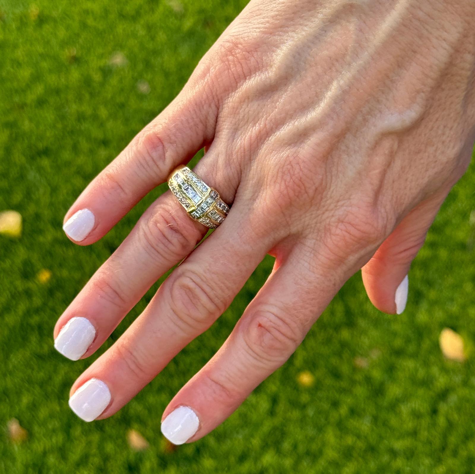 Este elegante anillo de diamantes en oro amarillo de 18k presenta un sofisticado diseño con 17 diamantes cuadrados talla esmeralda, engastados en canal para un aspecto elegante y sin juntas, y 20 diamantes redondos talla brillante, engastados en