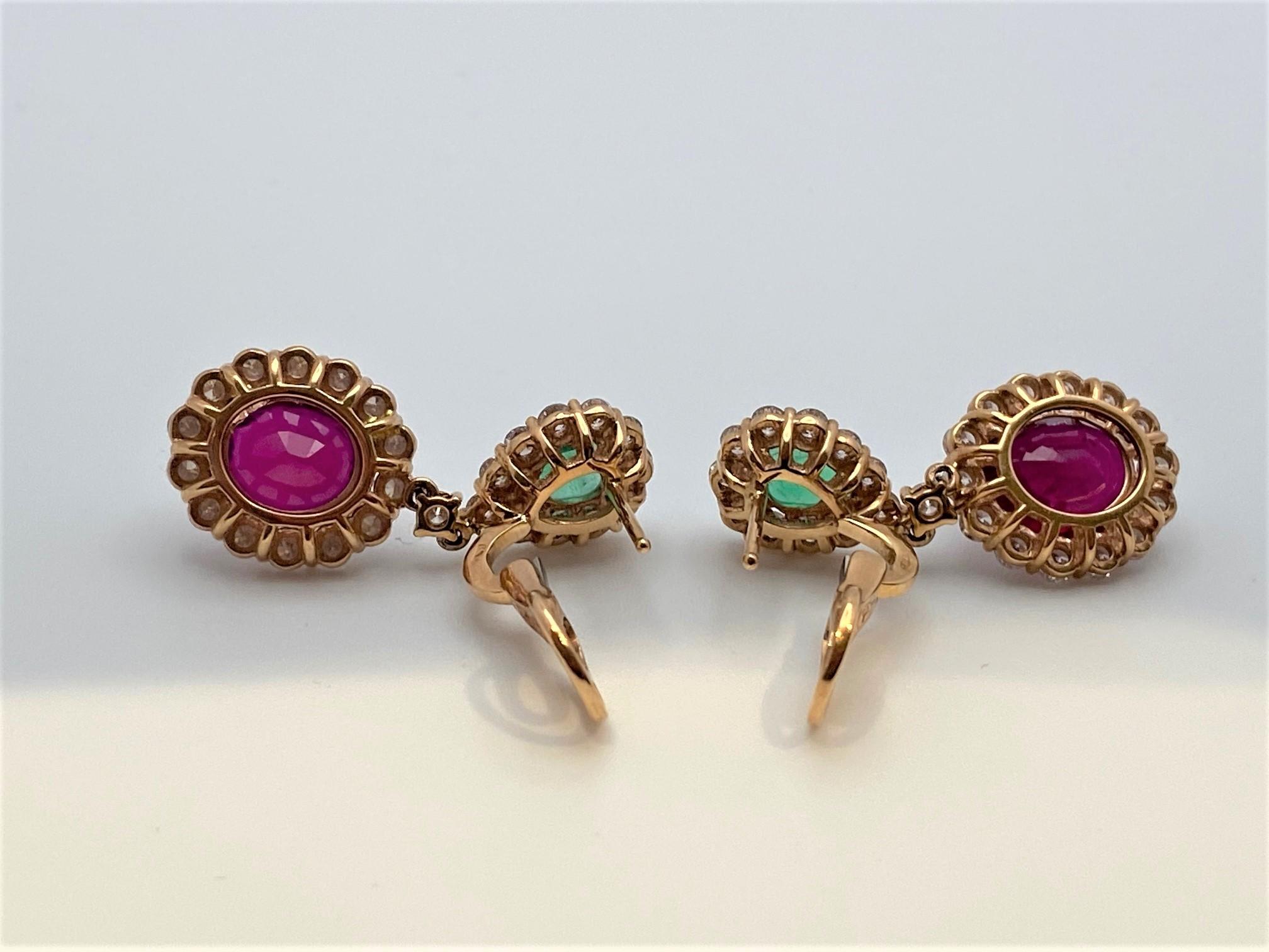Beautiful lady's drop earrings in 18KT rose gold featuring tear drop shaped emeralds weighing 1.05 carats with a French clip back set over oval cut vivid red rubies weighing 7.45 carats. Both gemstones are surrounded by round brilliant cut white