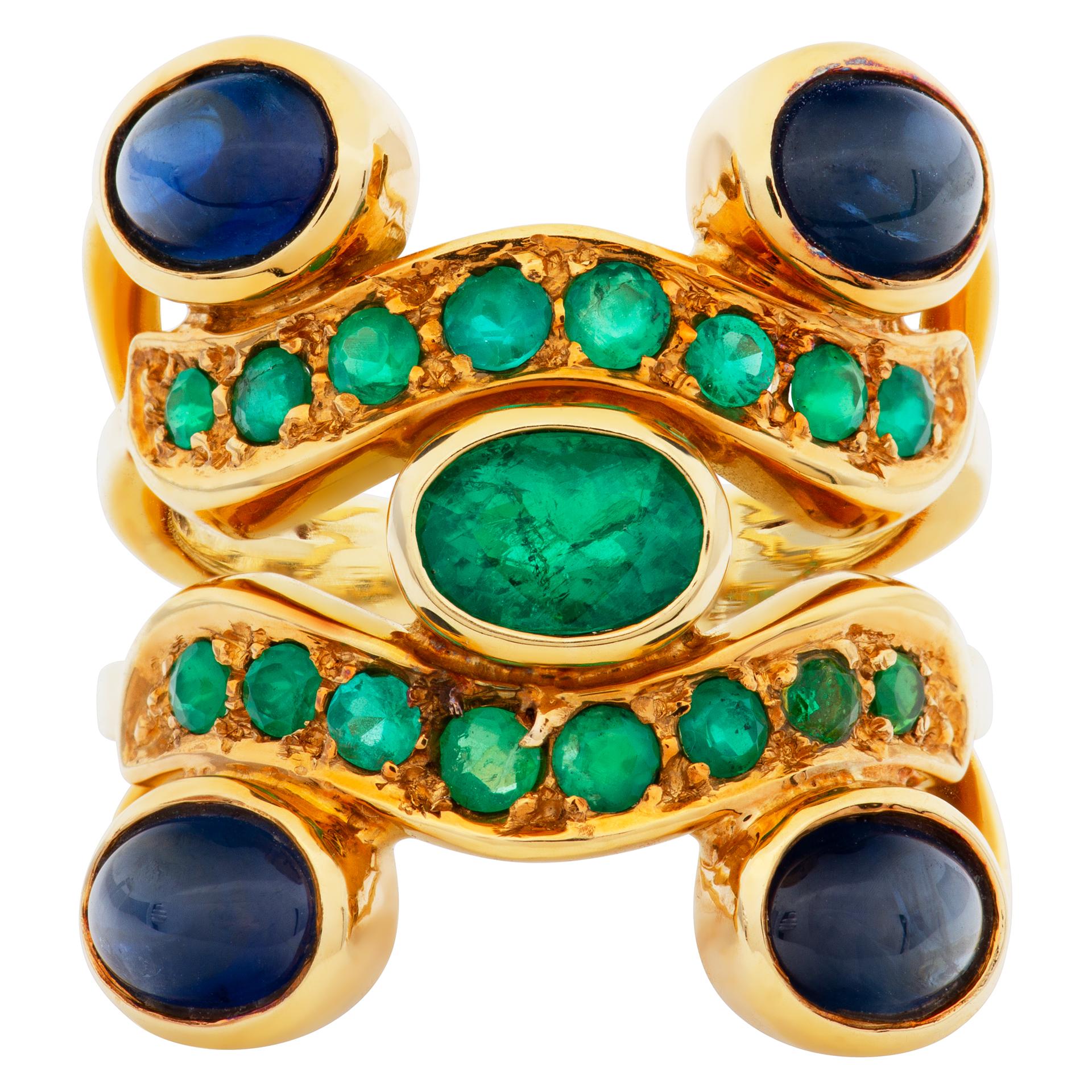 Aufwändiger Ring mit Smaragd und Cabochon-Saphir, gefasst in 18 Karat Gelbgold. Zentraler ovaler Smaragd von über 1 Karat. 4 Cabochon-Saphire von je ca. 1 Karat. 16 kolumbianische Smaragde mit Rundschliff, insgesamt ca. 1 Karat. Größe 10. Vorderes