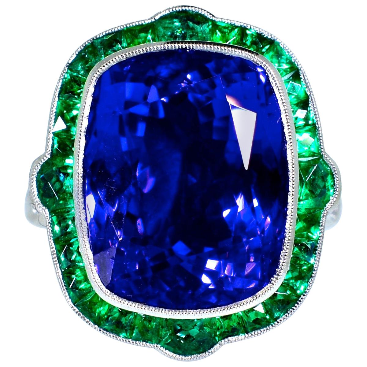 Fancy French cut natural Colombian emeralds displaying a bright green clear color surround one of the finest natural large Tanzanites we have encountered. This stone has a pure deep but exceedingly bright blue color with a slight hint of purple. 