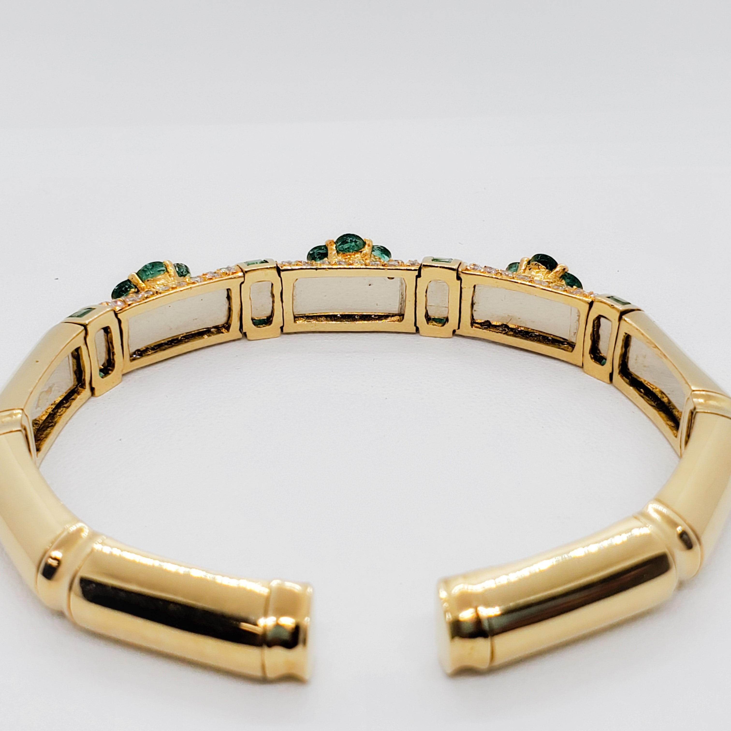 Stunning estate bangle showcasing deep green emeralds in multi shapes and 1.60 cts of good quality, white, and bright diamond rounds.  Handmade in 18k yellow gold.  Floral design is classic and evergreen.  This bangle is in excellent condition and