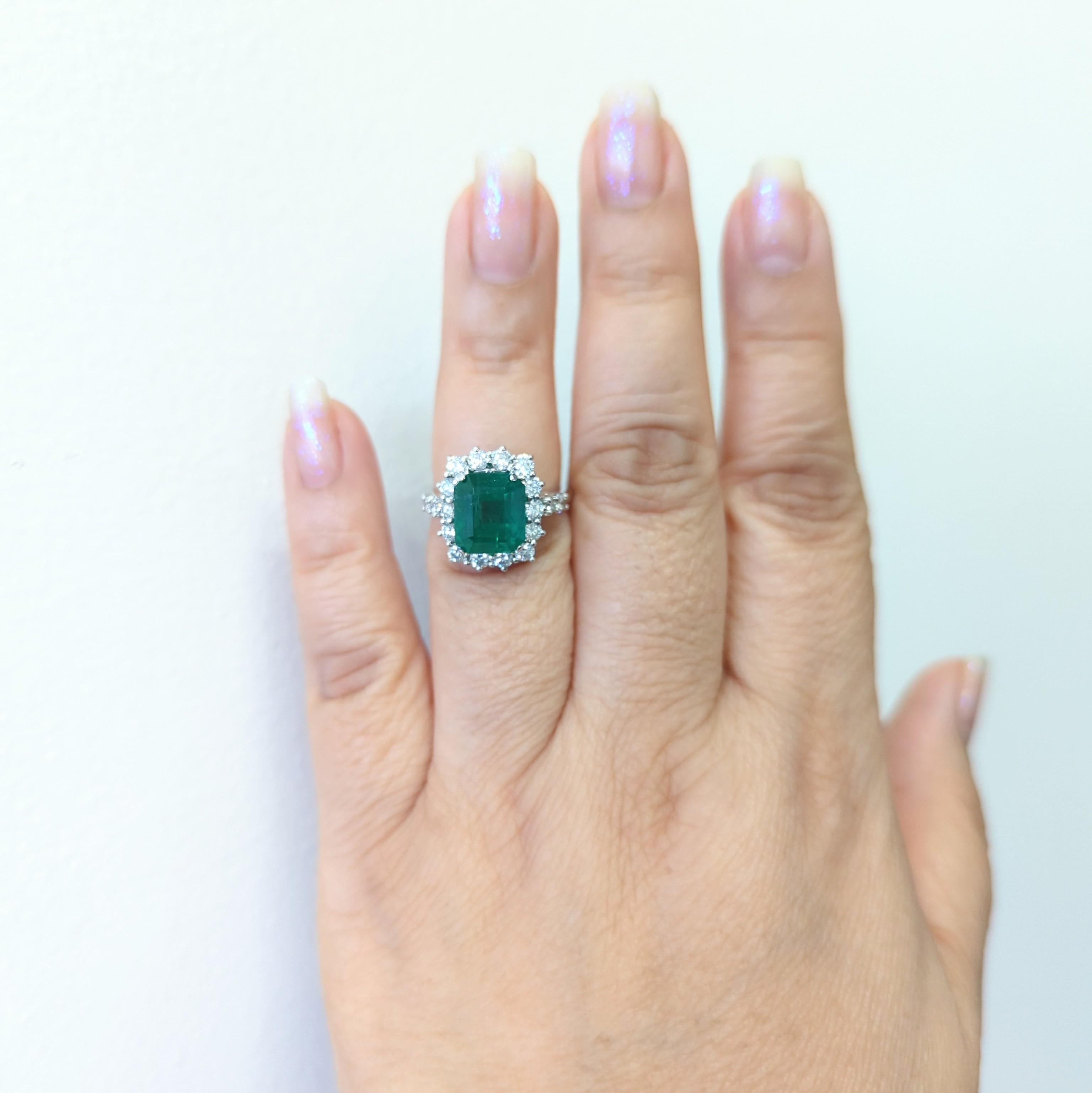Wunderschöner 4.15-karätiger Smaragd im Smaragdschliff mit weißen, runden Diamanten guter Qualität.  Handgefertigt aus 18 Karat Weißgold.  Ring Größe 7.