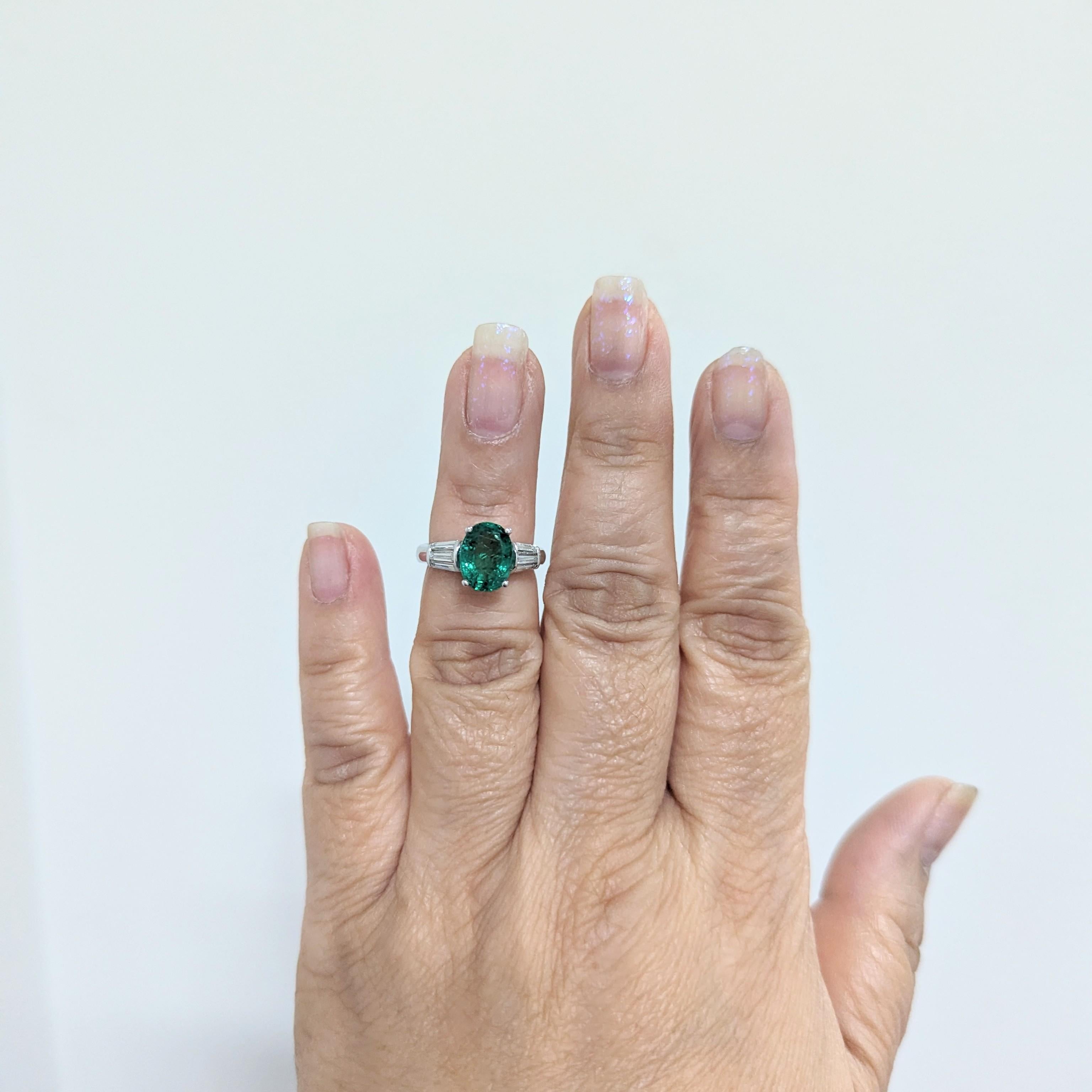 Beautiful 2.85 ct. emerald oval and white diamond baguette three stone ring handmade in 18k white gold.  Ring size 5.25.