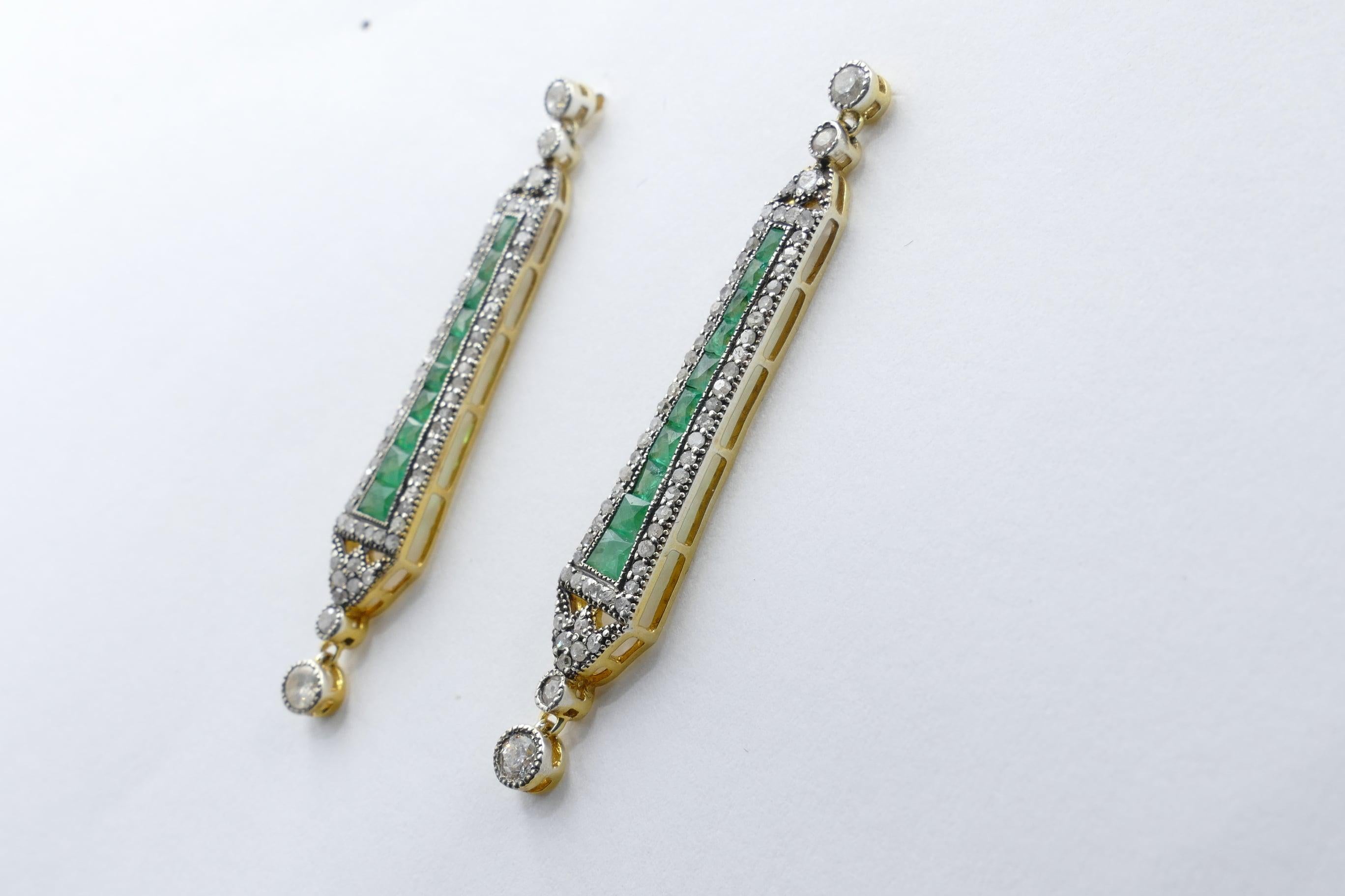 20 Emeralds, baguette cut, channel set, bluish-green in colour form the main feature of these very modern earrings.
There are also 116 round brilliant cut Diamonds as well as another 10 Diamonds milligrain set, the total weighing close to 1mcarat of