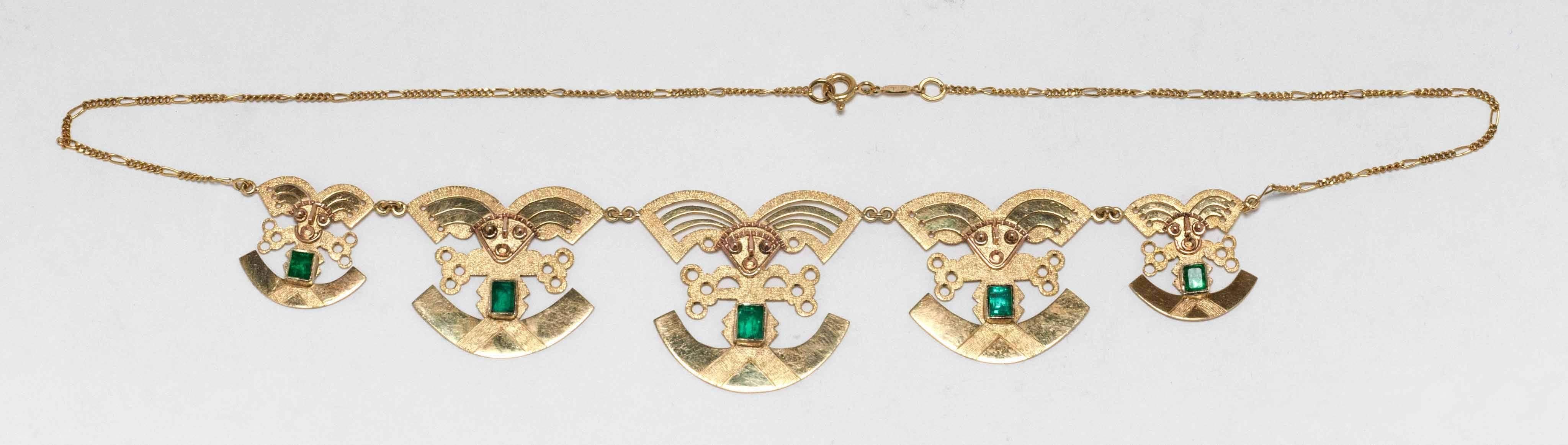 The design represents a ceremonial Tumi knife, associated with Pre Inca cultures in the coastal area of Peru. This marvelous tribal style features five charming figures each set with a vivid green natural Colombian emerald in yellow and rose gold.