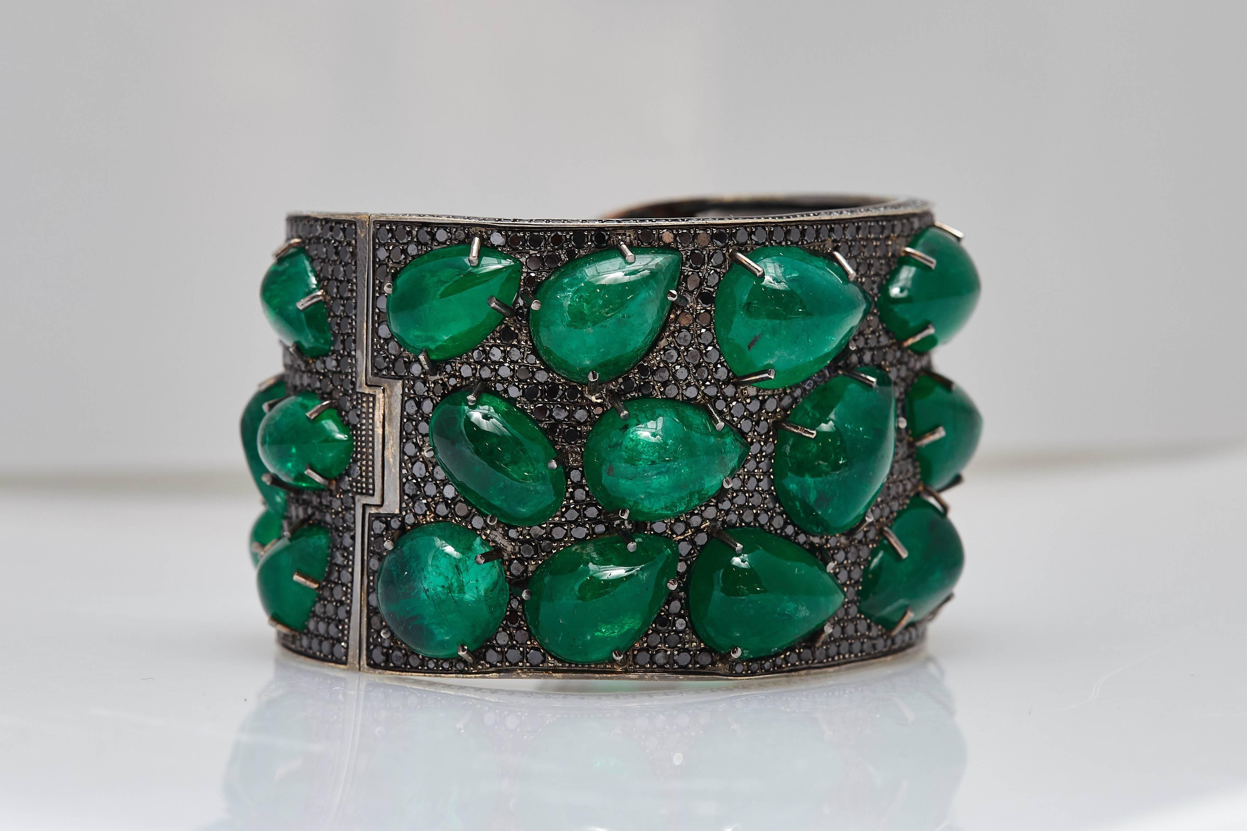 An impressive cuff bracelet in 18kt black gold with 31 cabochon emeralds (app. 180 cts) and black diamonds (app. 15.65 cts). Made in Italy, circa 1980

