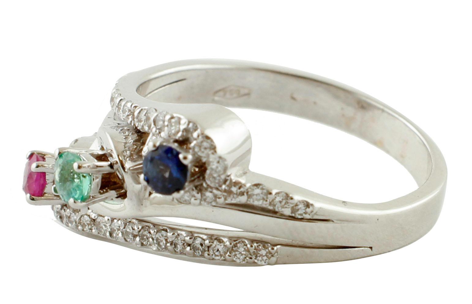 Amazing modern ring in 18k white gold steucture mounted with three stones in the center: one ruby, one emerald, one blue sapphire and adorned with 0.43 ct of little white diamonds around.
Diamonds 0.43 ct
Emerald, Rby, Blue Sapphire 0.32 ct  
Total