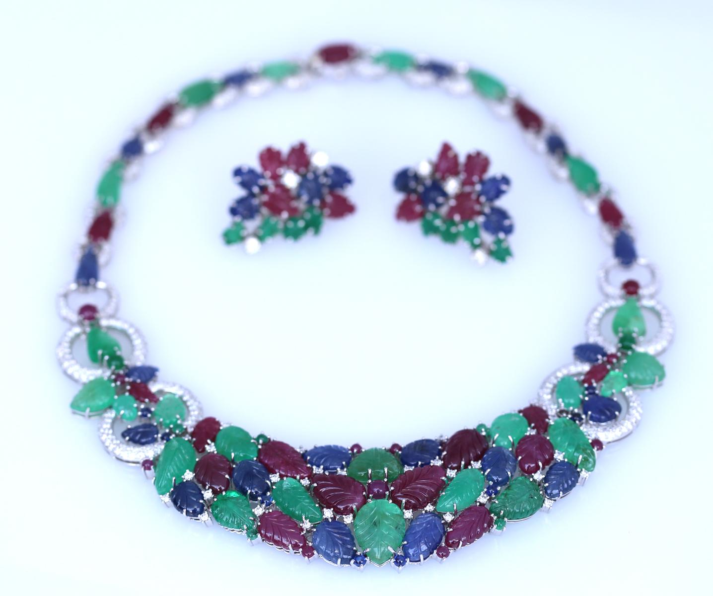 Carved Emeralds, Sapphires & Rubies with a round cut fine Diamonds. Necklace and earrings set. 18 Karats White Gold.
It is a Tutti Frutti design and style executed to a highest standards and finished with exquisite details. It has magical mix of