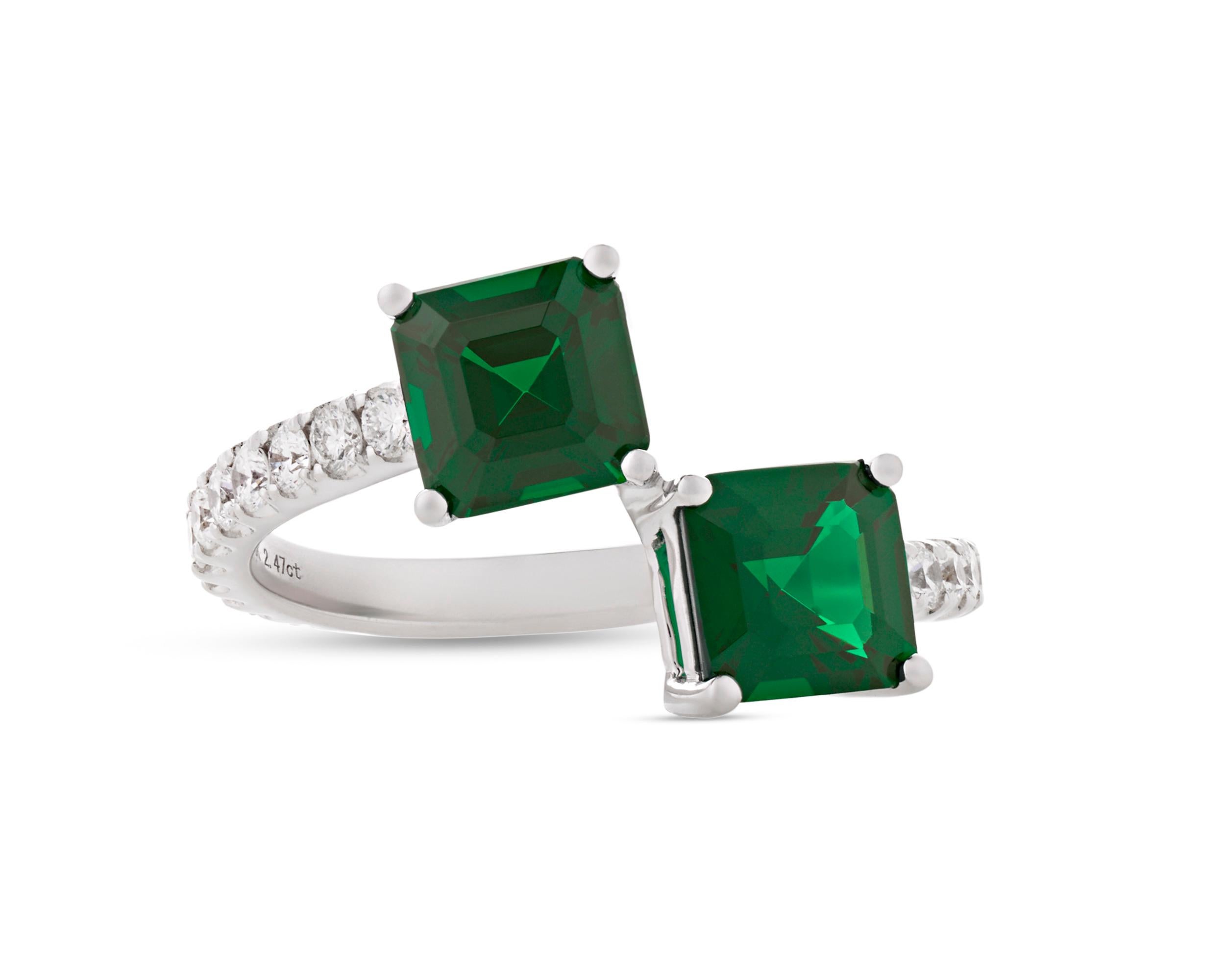Asymmetrical yet perfectly balanced, this emerald bypass ring exudes sophistication. Weighing a combined 2.47 carats, the emeralds display a lush, deep green hue accentuated by the bright white of accent diamonds totaling 0.54 carat. Set in 18K
