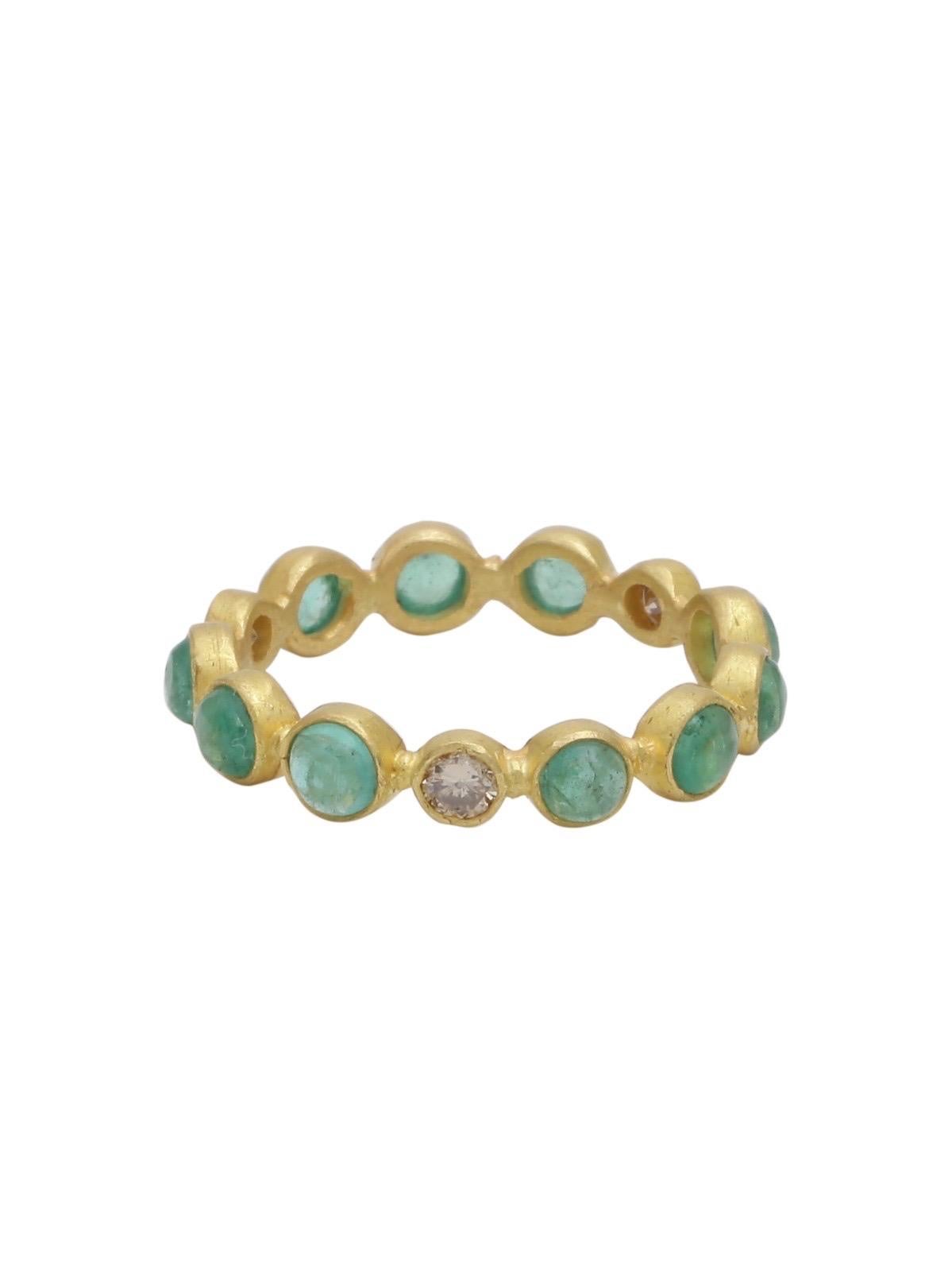 This beautifully handcrafted eternity band in 22k Matte gold finish is adorned with round emerald cabochons and diamonds . 
The ring is completely handmade and was created by extremely talented artisans of Jaipur - the city known worldwide for its