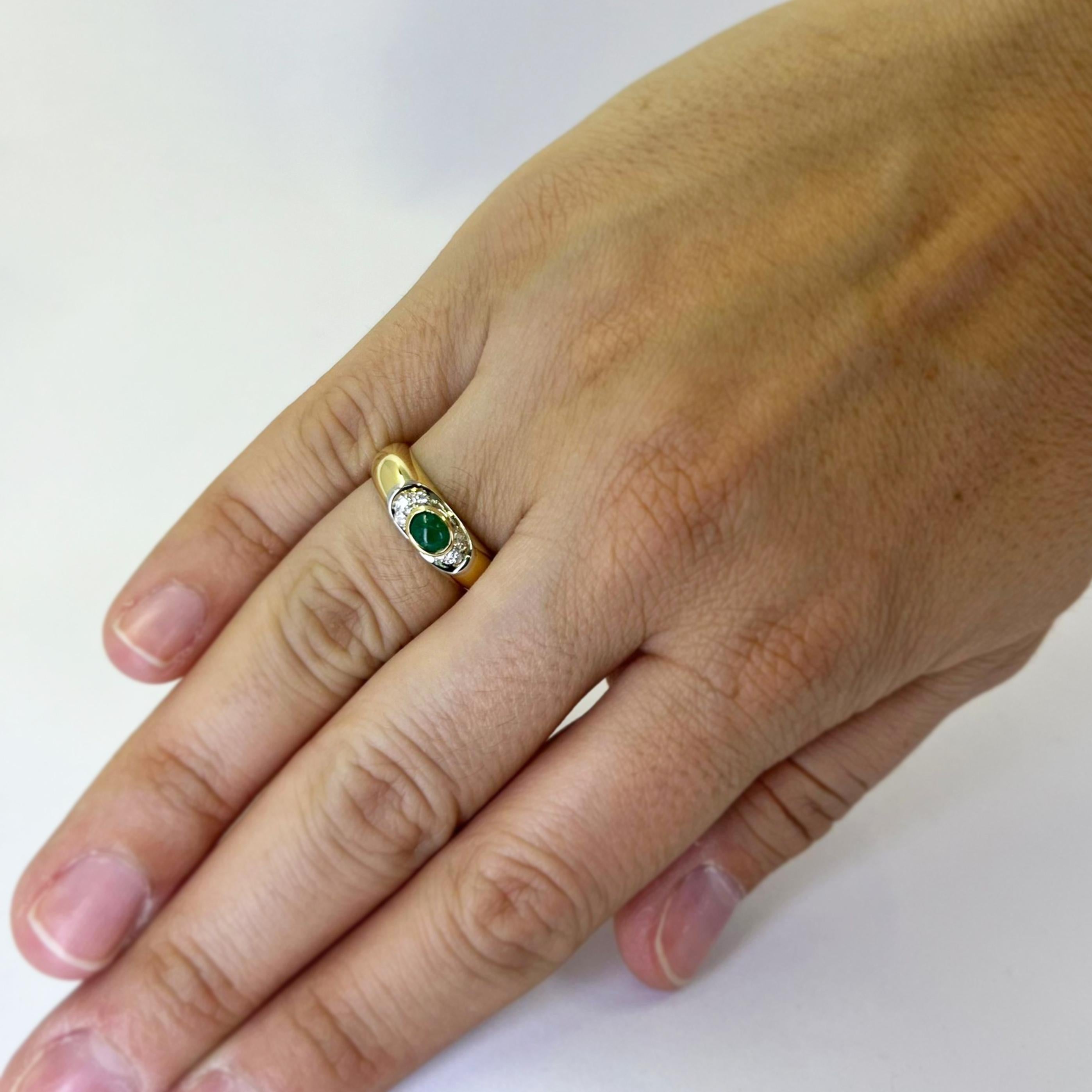 18 karat yellow gold band featuring a 4.5mm x 3mm cabochon emerald accented by 6 round brilliant cut diamonds of VS clarity and H color totaling 0.06 carats. Finger size 6.5. Includes One Sizing Service Prior to Shipping, Upon Request. Finished