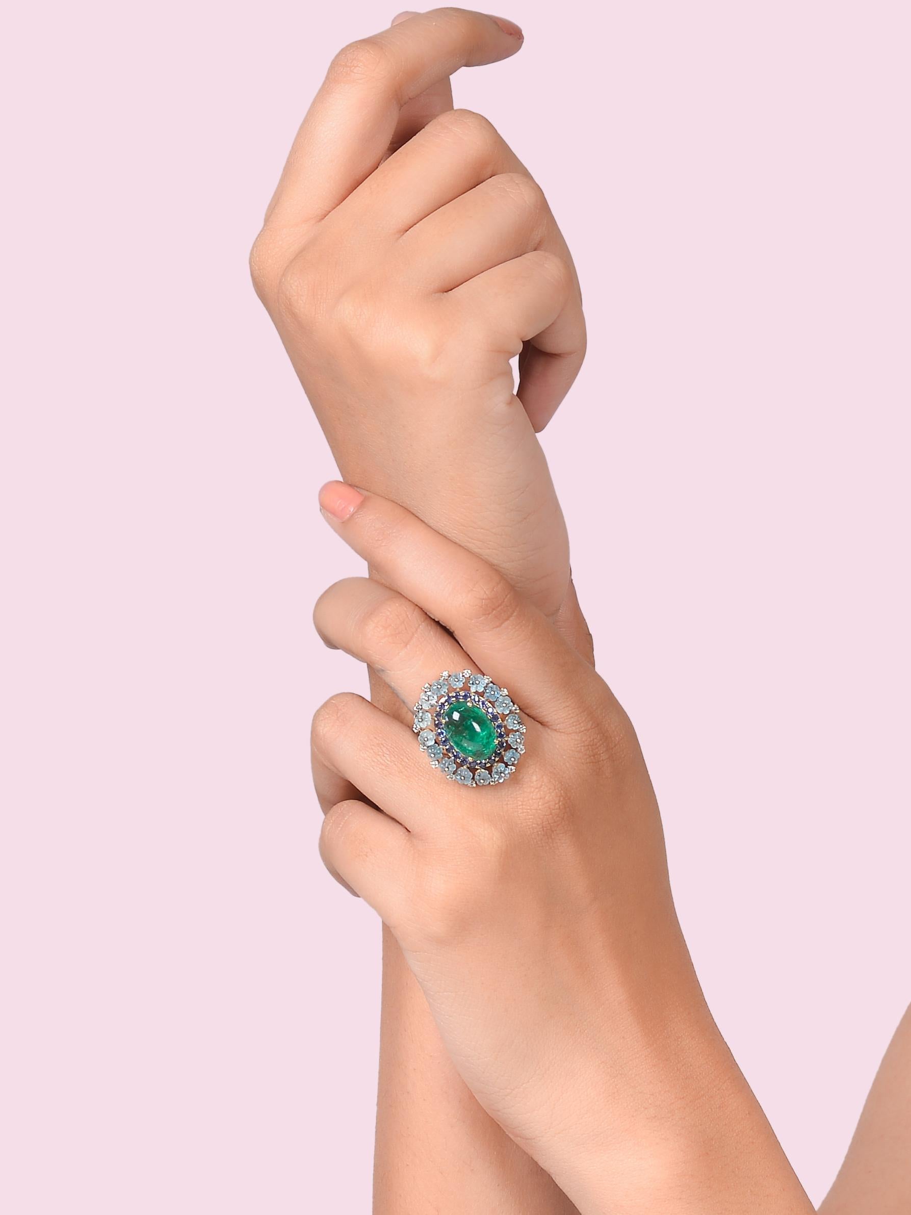A unique one of a kind cocktail ring with a beautiful blend of precious stones.
The central Emerald cabochon is complimented by the Sapphires and then you will notice hand carved Aquamarine beads with diamonds on top.
The ring is made in 14K yellow