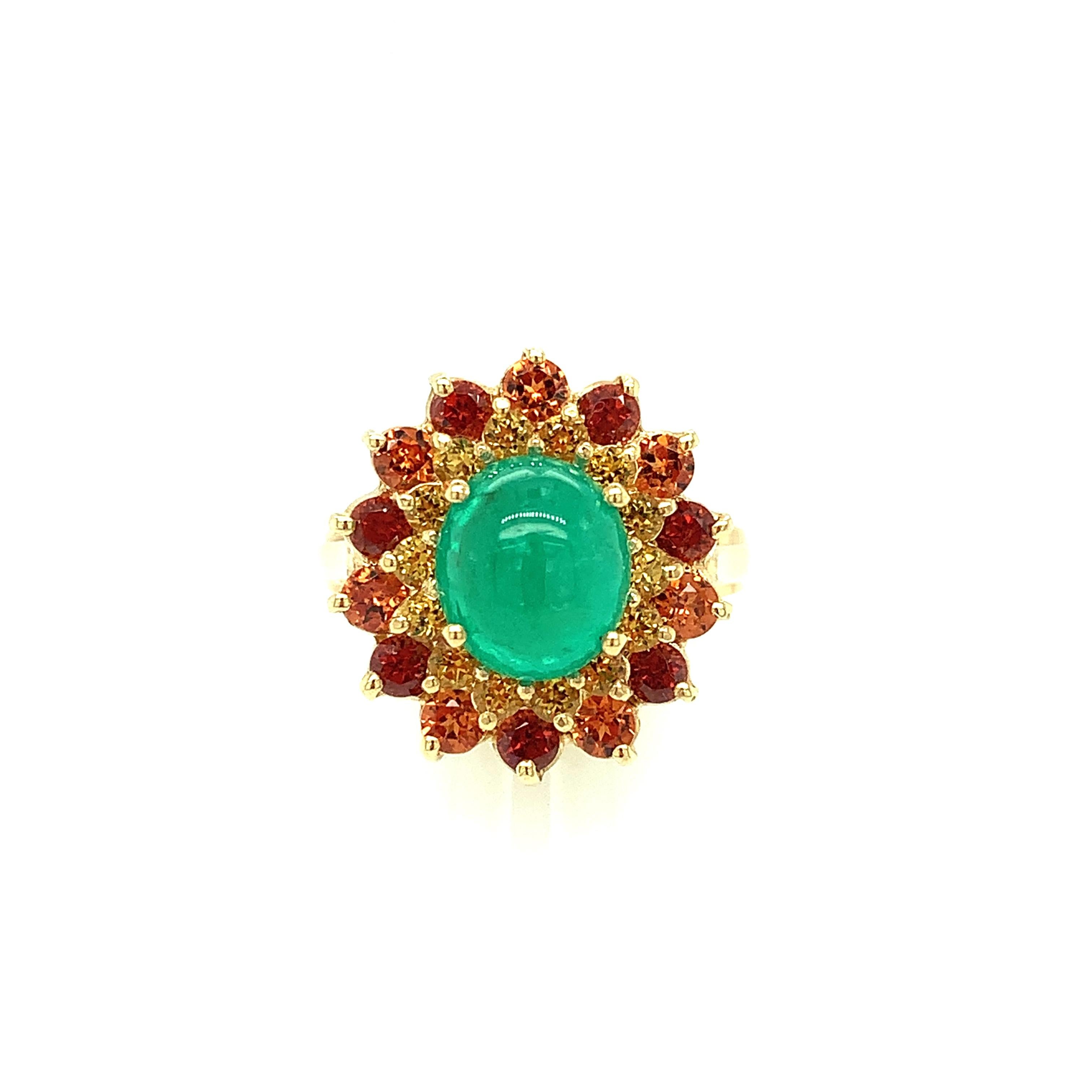 A richly colored emerald cabochon is the highlight of this pretty 14k yellow gold cocktail ring. The emerald is highly translucent and a lovely, vibrant color. An inner halo of bright golden yellow tourmalines surround the center gem, with an outer