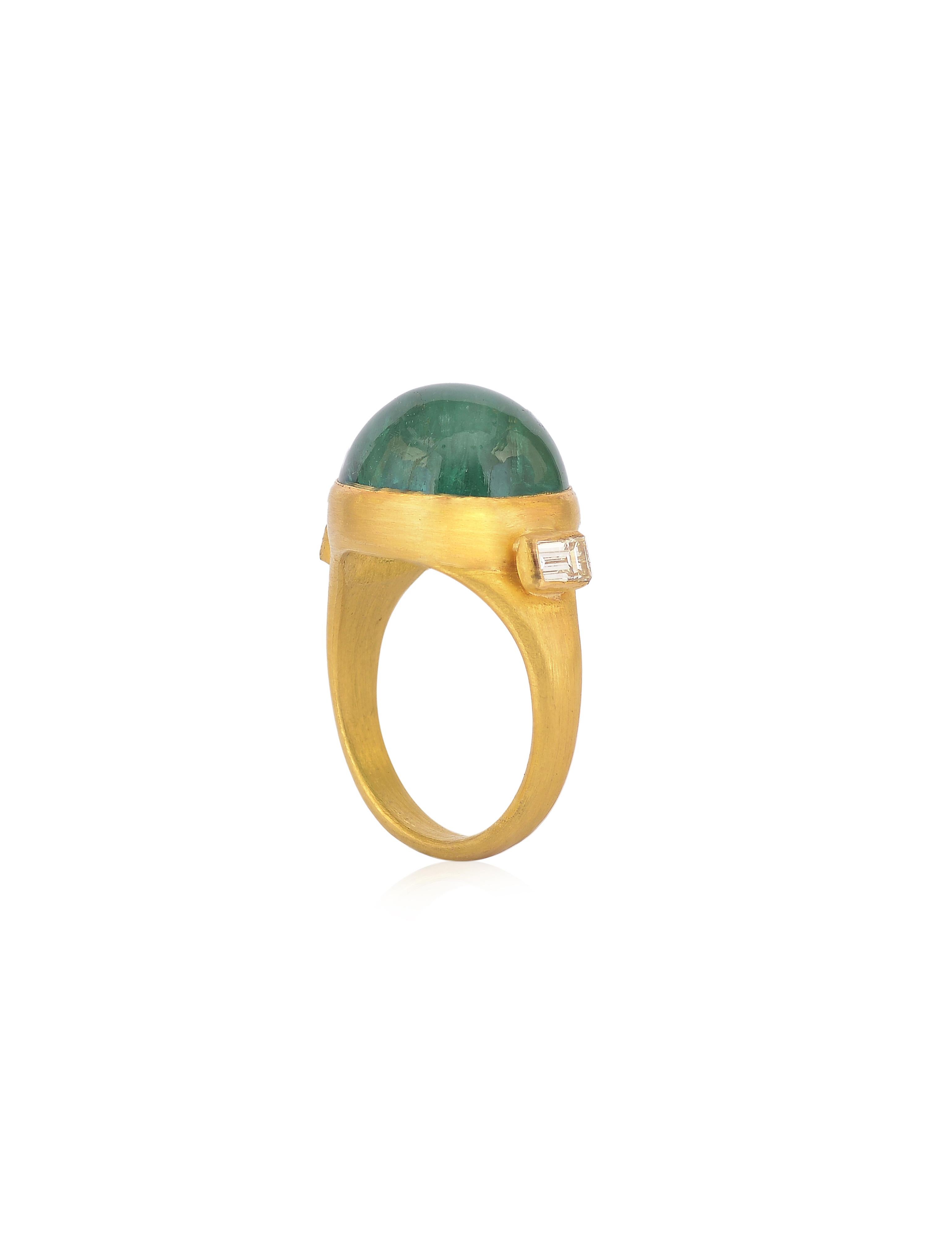 Ein schicker Smaragd-Cabochon-Ring mit 2 Diamant-Baguetten auf beiden Seiten. 
Der Ring ist handgefertigt in 22K Gold mit einer matten Oberfläche, um die Farbe der Steine zu ergänzen und hervorzuheben. Die Farbe des Smaragds hebt den Statement-Ring