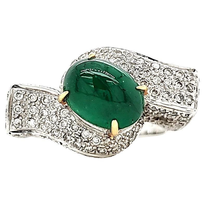 Immerse yourself in a world of timeless elegance with our Emerald Cabochon and Diamond Engagement Ring—an embodiment of sophistication and luxury. 

The centerpiece of this ring boasts a magnificent 2.11-carat Emerald Cabochon, captivatingly encased
