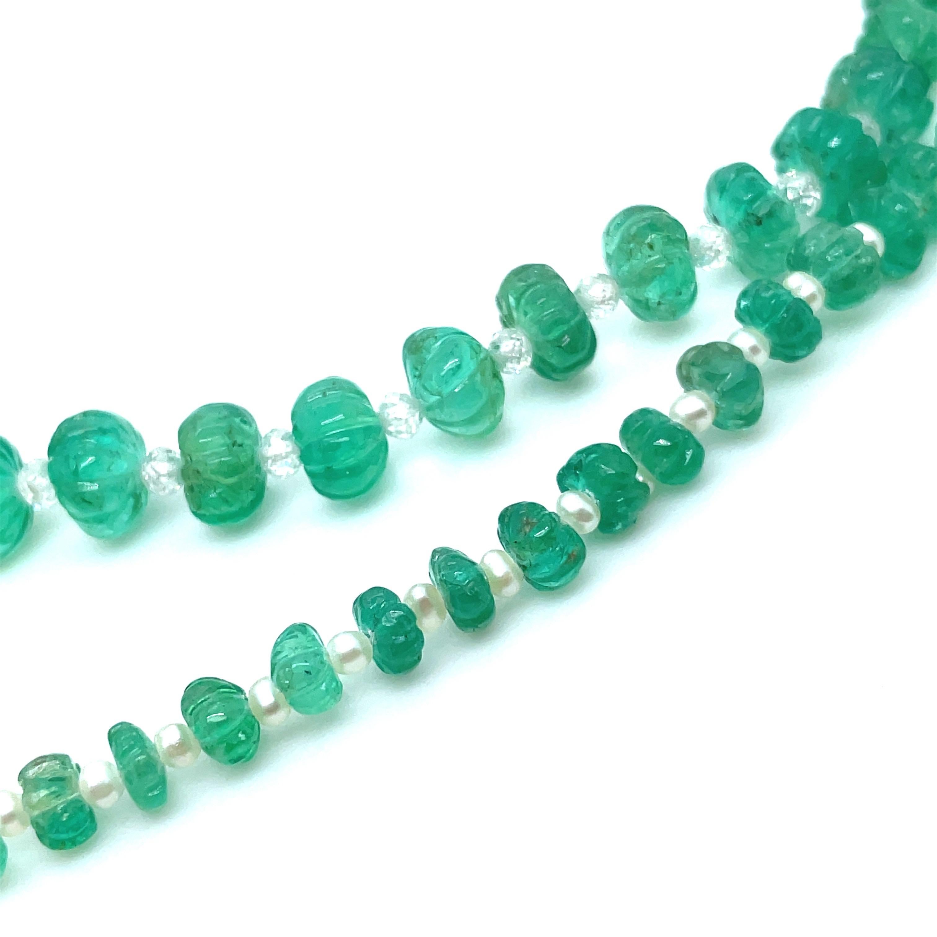 Originating from Zambia, Africa, this exquisite necklace features 125 emerald carvings totaling a magnificent 106.32 carats, complemented by 53 lustrous pearls weighing 5.16 carats.

It is also accentuated with 53 dazzling briolette diamonds