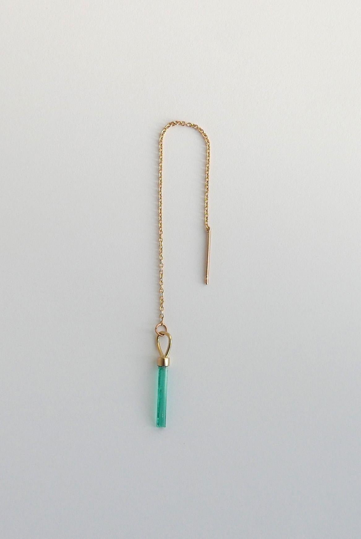 Dieser zeitgenössische Ohrring mit einer einzigen Kette zeigt einen natürlichen kolumbianischen Smaragd in Nadelform auf einer feinen 18-karätigen Goldkette mit Stiftrückseite.  Die Kette kann durch das Ohr gezeichnet werden, um die Länge zu