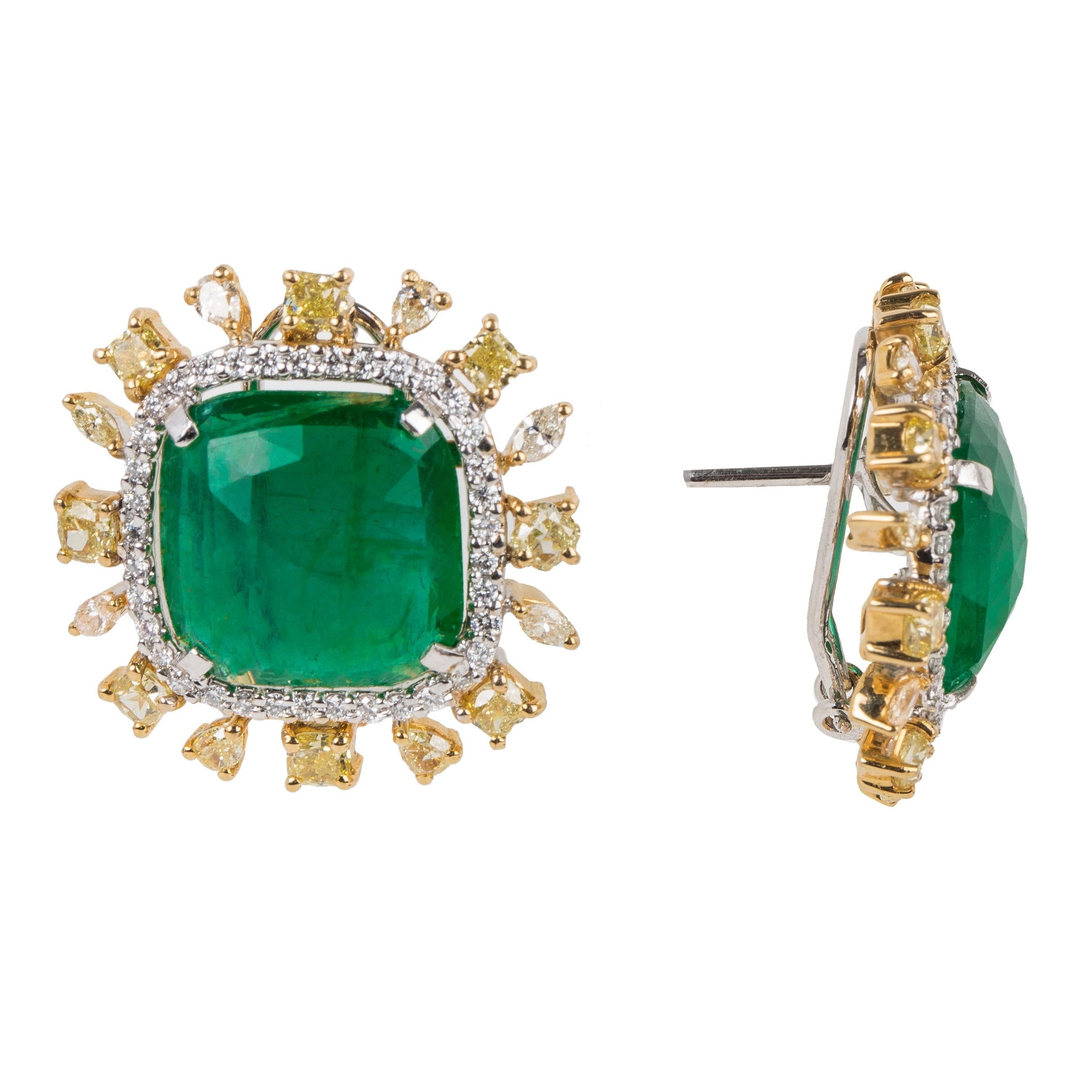 This pair of earrings features a unique emerald checkerboard cut in a square shape. Around the gorgeous stone, is a halo of diamonds. The outside is studded with fancy color diamonds. This natural Zambian emerald is saturated with vivid green color. 