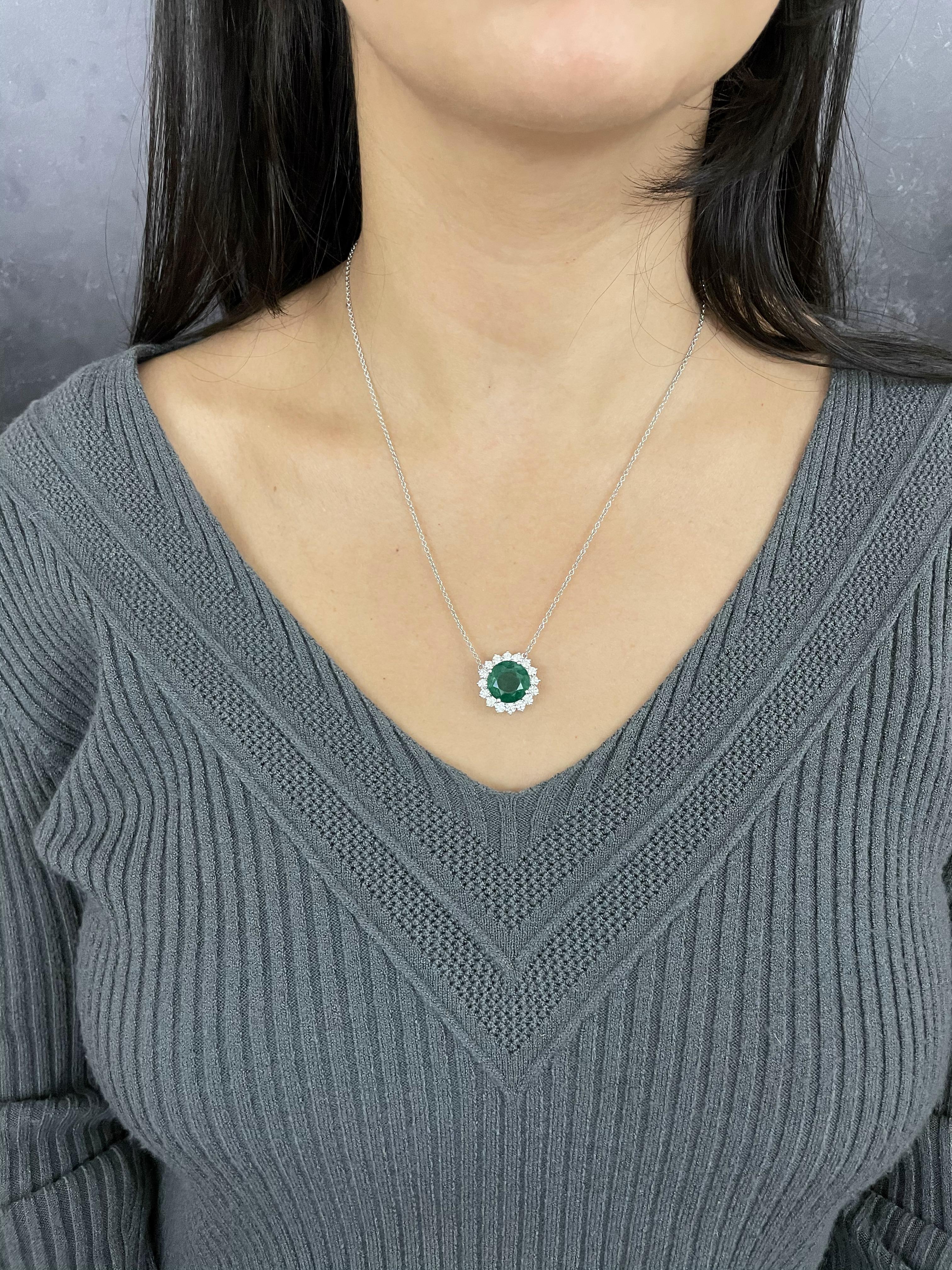Bold and beautiful, this stunning 7.05 Carat Emerald is encircled by 16 sparkling White Diamonds.  The pendant is suspended by a 17-inch franco chain.  

Material: 18k White Gold 
Stone Details: 1 Round Cut Emerald at 7.05 Carats
16 Round Diamonds