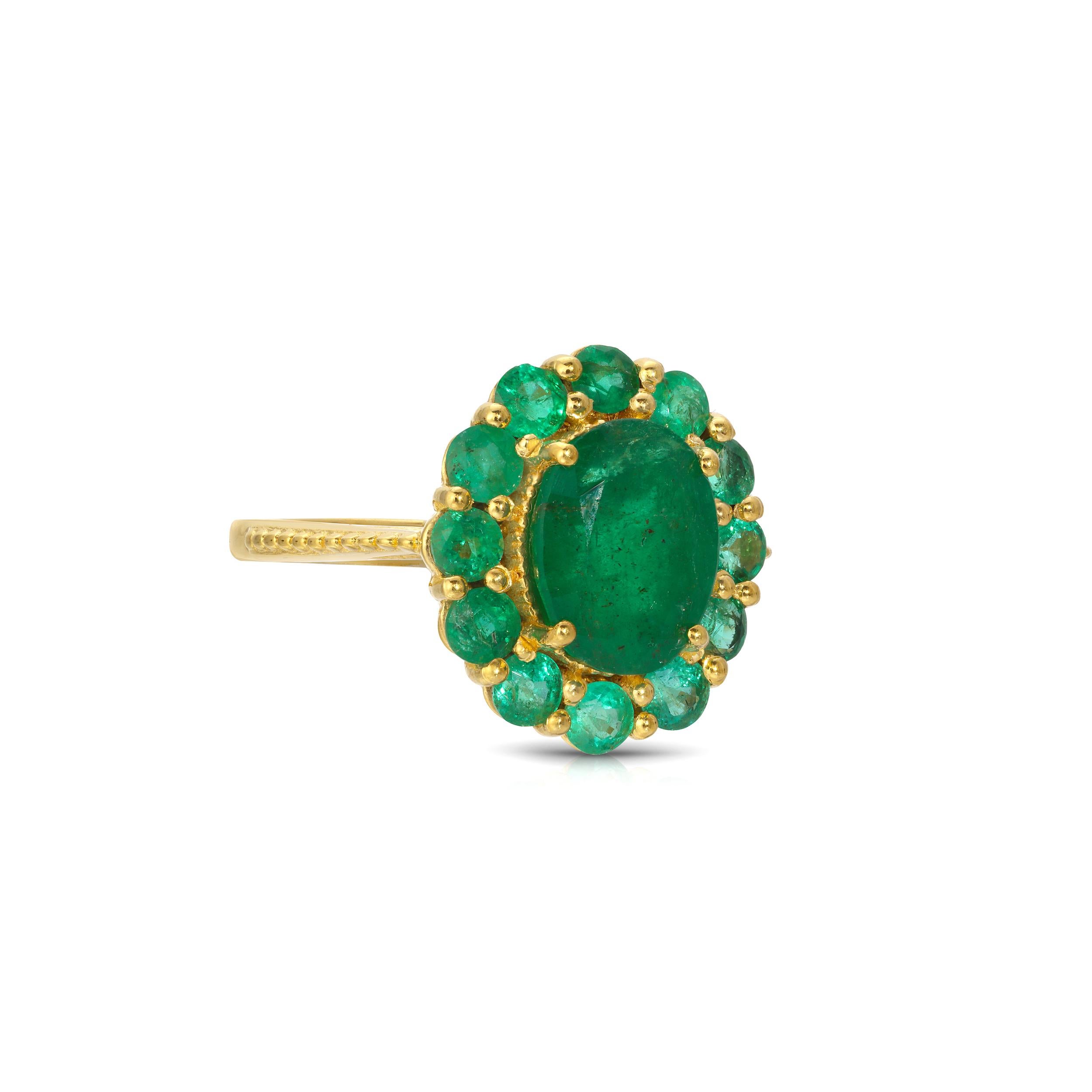 A stunning cocktail ring featuring vibrant gemstones. This ring features a fiery center emerald enhanced by a setting of faceted emeralds of exceptional clarity in a modern cluster design. This ring is set in 22 Karat Gold overlay Silver and