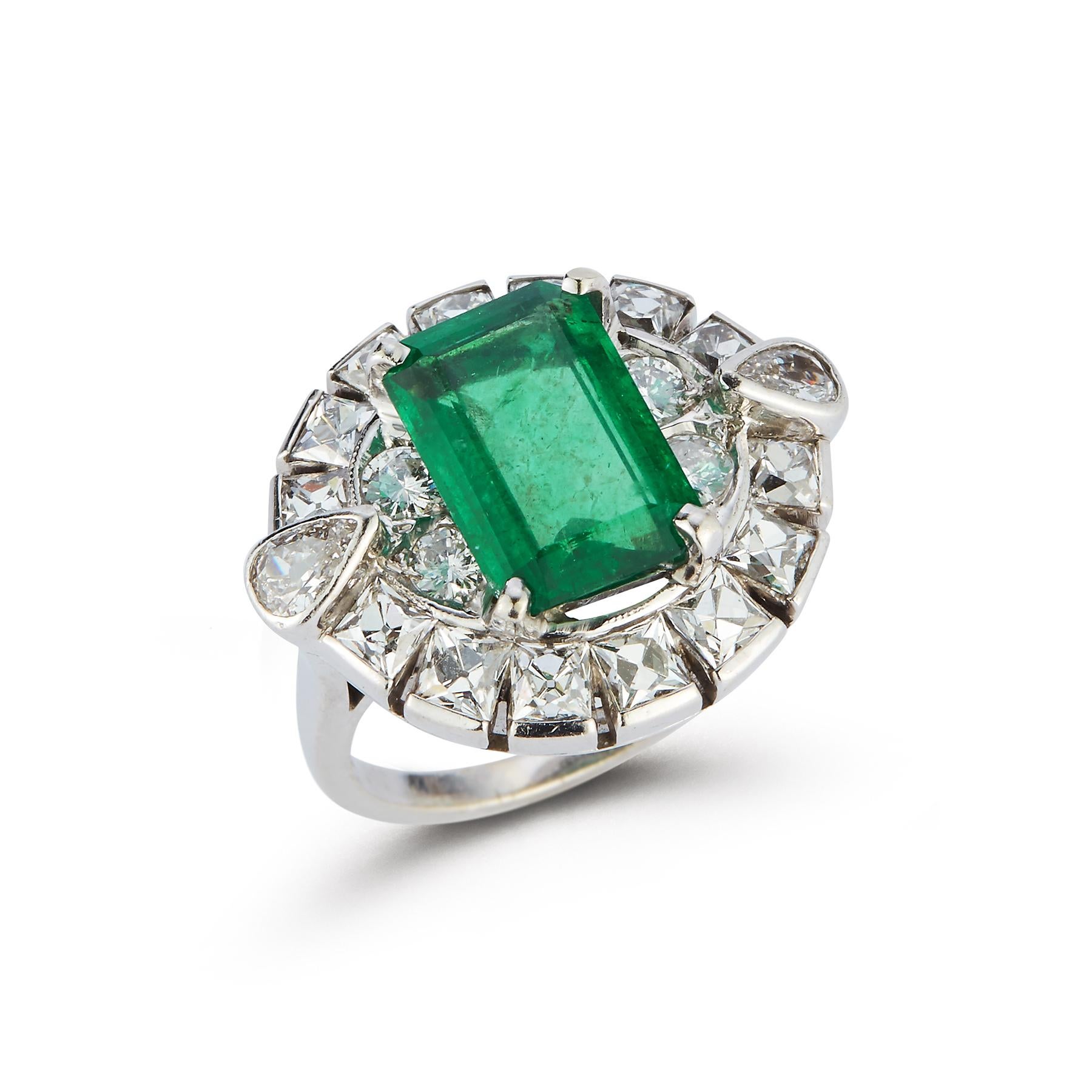 Emerald Cocktail Ring

Emerald approximately 5.62 Carat with 2 Pear Shape Side Diamonds approximately 0.28 Carats and 
4 Side Brilliant Cut Diamonds approximately 0.40 Carats
Within a border of 14 French Cut Diamonds approximately 2.30 Carats
14k