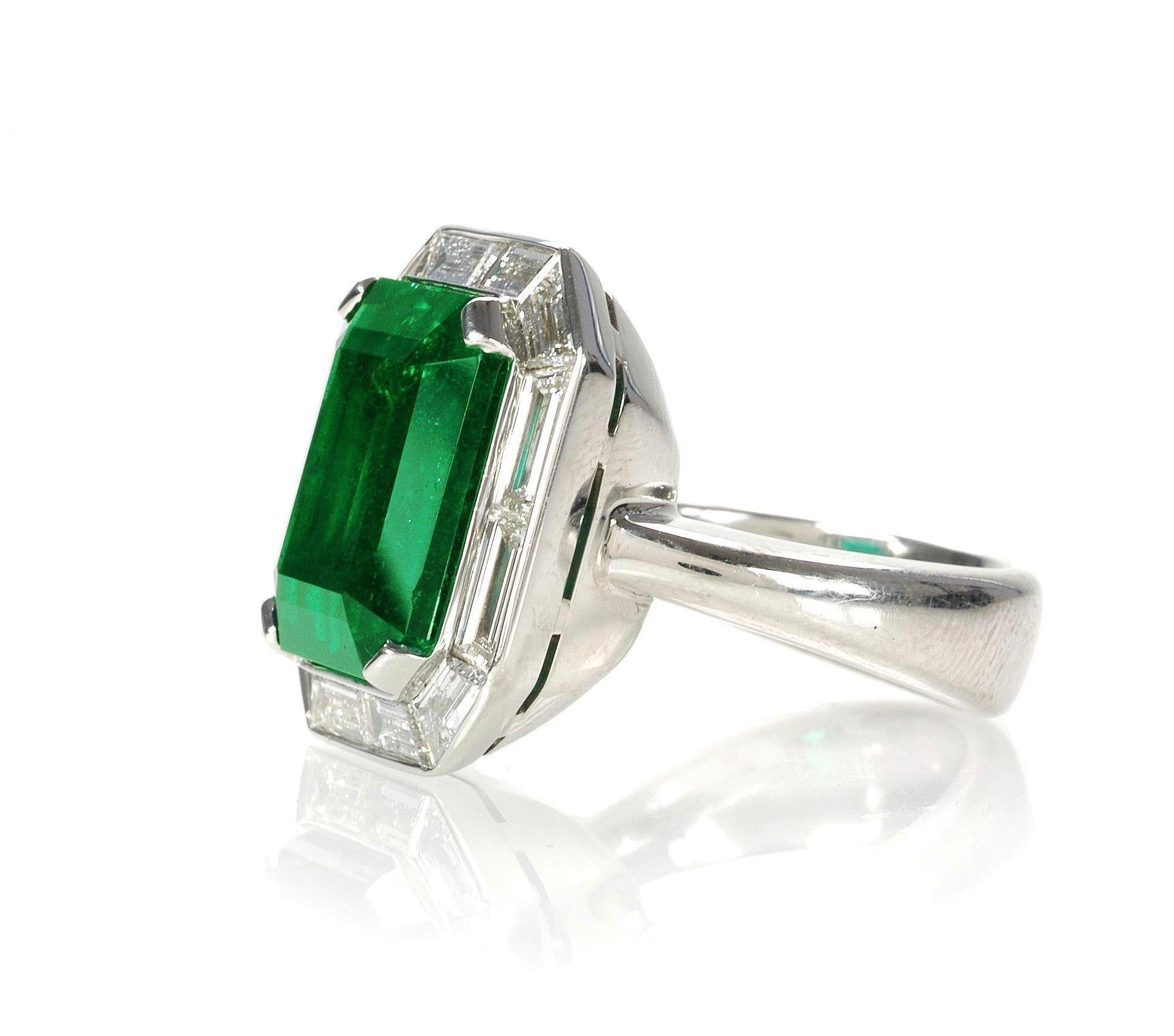 The rich green 13.48cts emerald cut emerald is set in an exquisite, and completely custom made, platinum and diamond mounting.  The baguette cut diamonds (12=2.50cts) were all individually cut to perfectly surround the center stone.  Made in one of