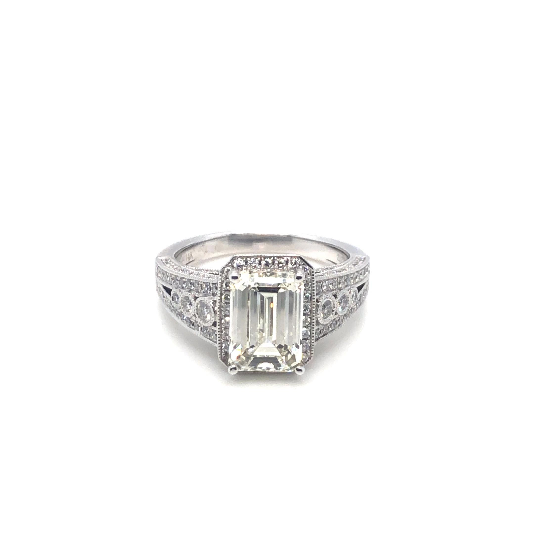 Emerald Cut 3.01ct Diamond Engagement Ring in 14K White Gold. The ring features a 3.01 carat emerald cut diamond, L color, SI2 clarity, GIA certified. The ring is accented by 0.88ctw of round diamonds. Size 7.5