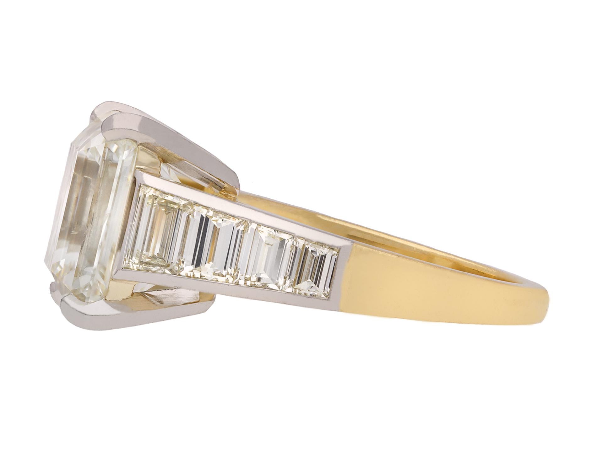 Emerald-cut diamond flanked solitaire ring. Centrally set with an octagonal emerald-cut diamond, N colour, VS2 clarity, with a weight of 6.95 carats in an open back four claw setting, flanked by eight tapered baguette diamonds in open back half