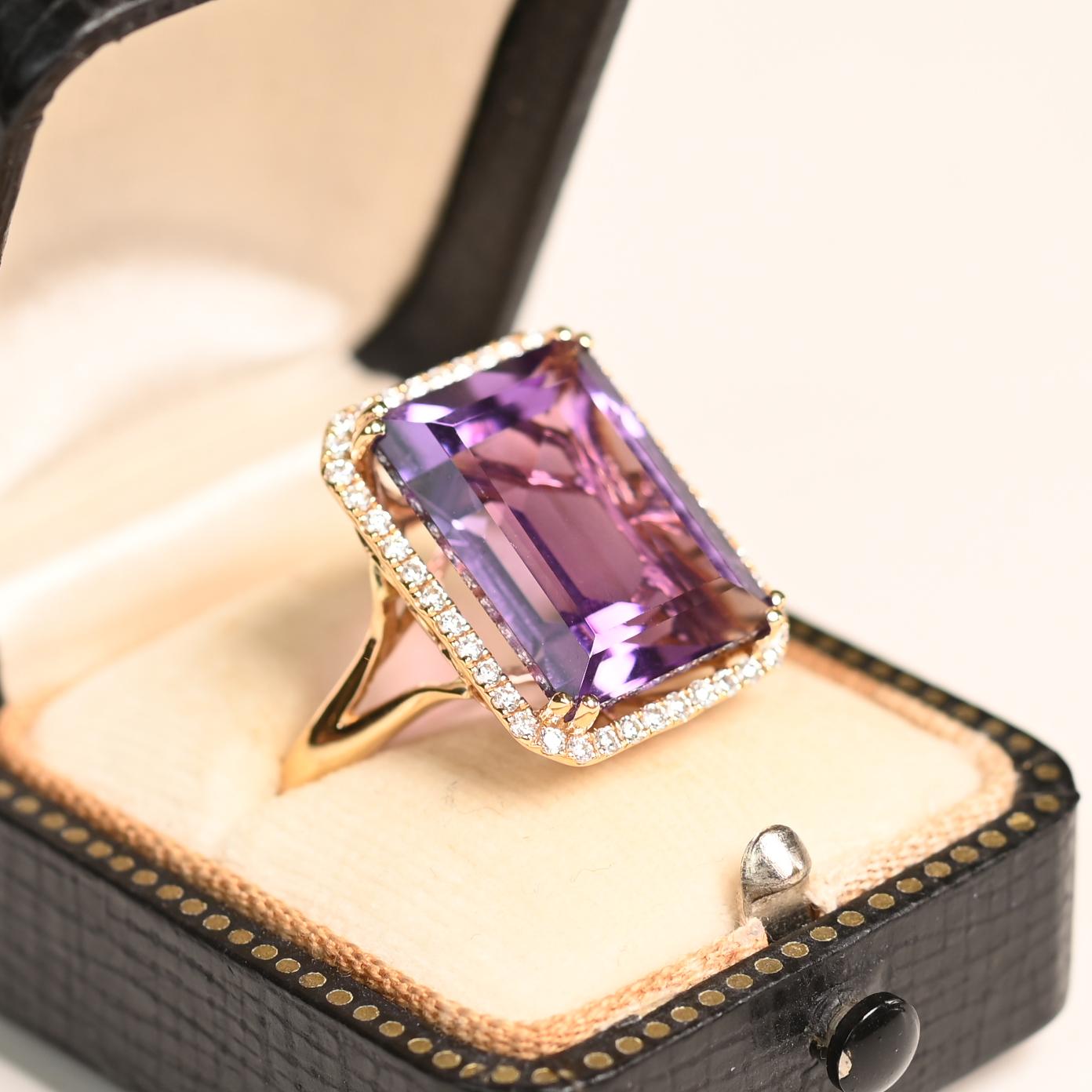 Questo straordinario anello di pietre preziose mette in mostra una squisita ametista taglio smeraldo di circa 11,20 carati. L'ametista, tenuta saldamente in un'incastonatura, irradia una tonalità profonda e regale che affascina lo sguardo. La pietra