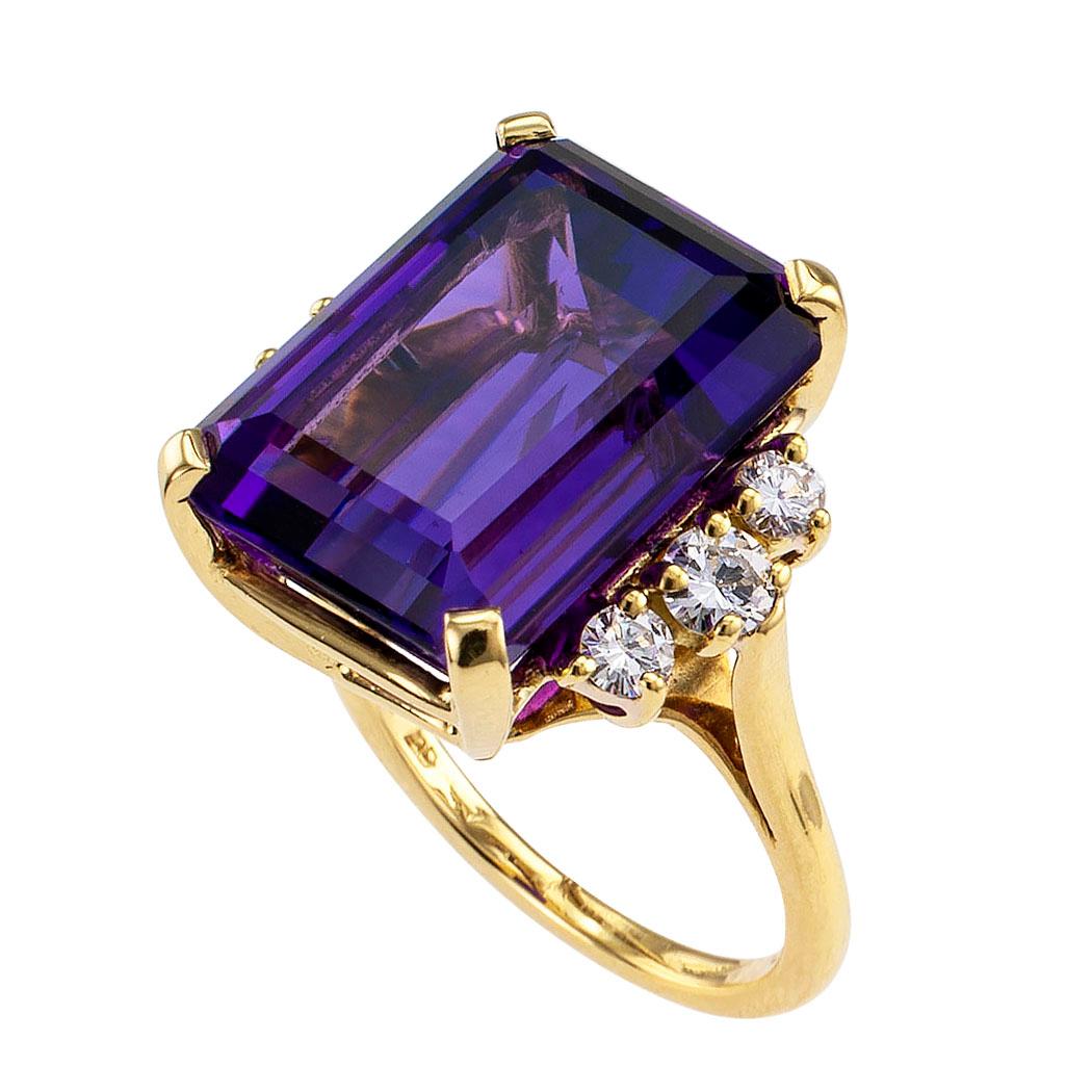 Amethyst diamond and yellow gold cocktail ring circa 1970. Centering upon an emerald-cut amethyst weighing approximately 13.00 carats, between shoulders set with trios of graduated round brilliant-cut diamonds totaling approximately 0.58 carat,
