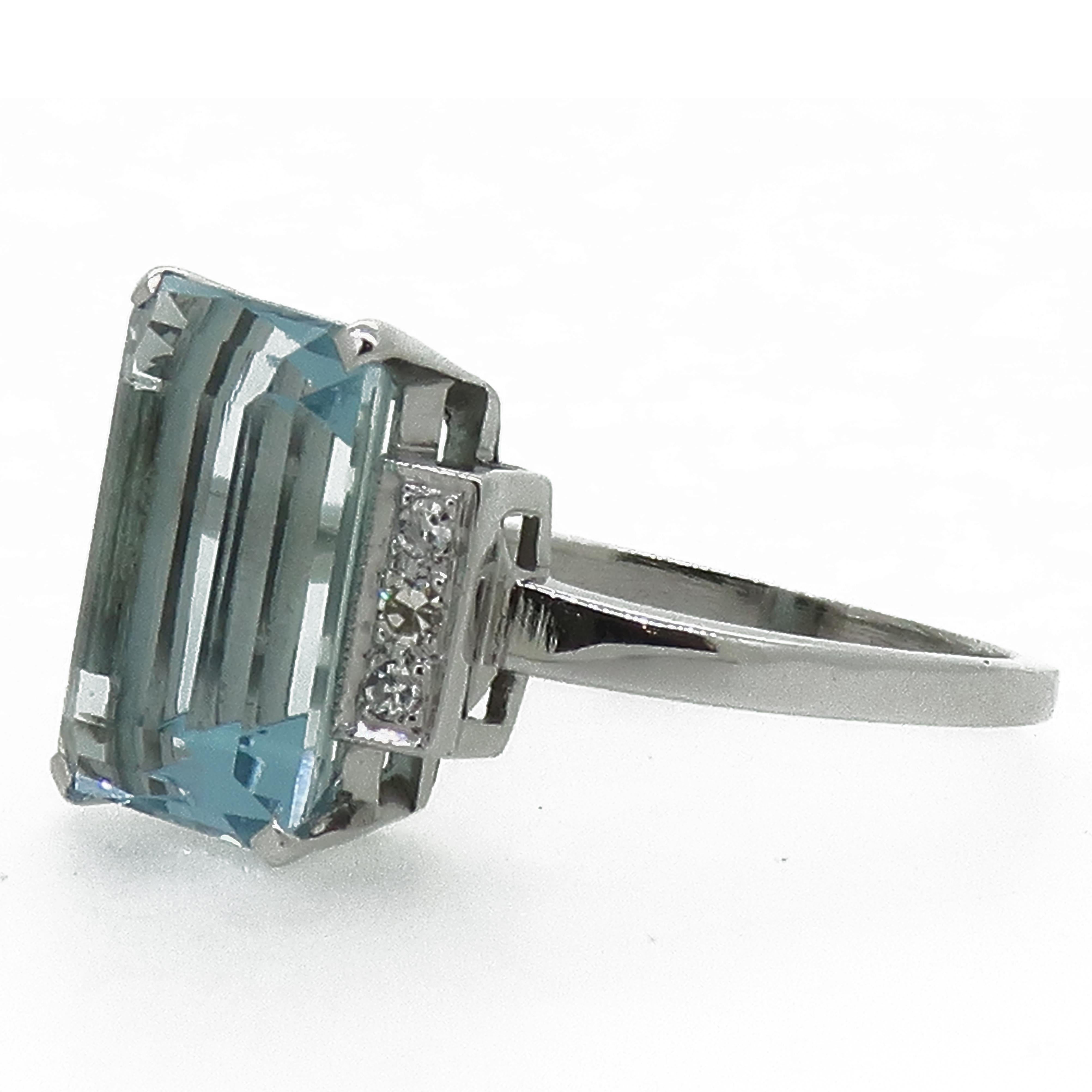 Emerald Cut Aquamarine And Diamond Cocktail Ring 

Large emerald cut aquamarine bordered by three 8 cut diamonds on each side. This incredible stone measures 13mm x 9.6mm and is set in a four claw setting. 
Simple and elegant white metal