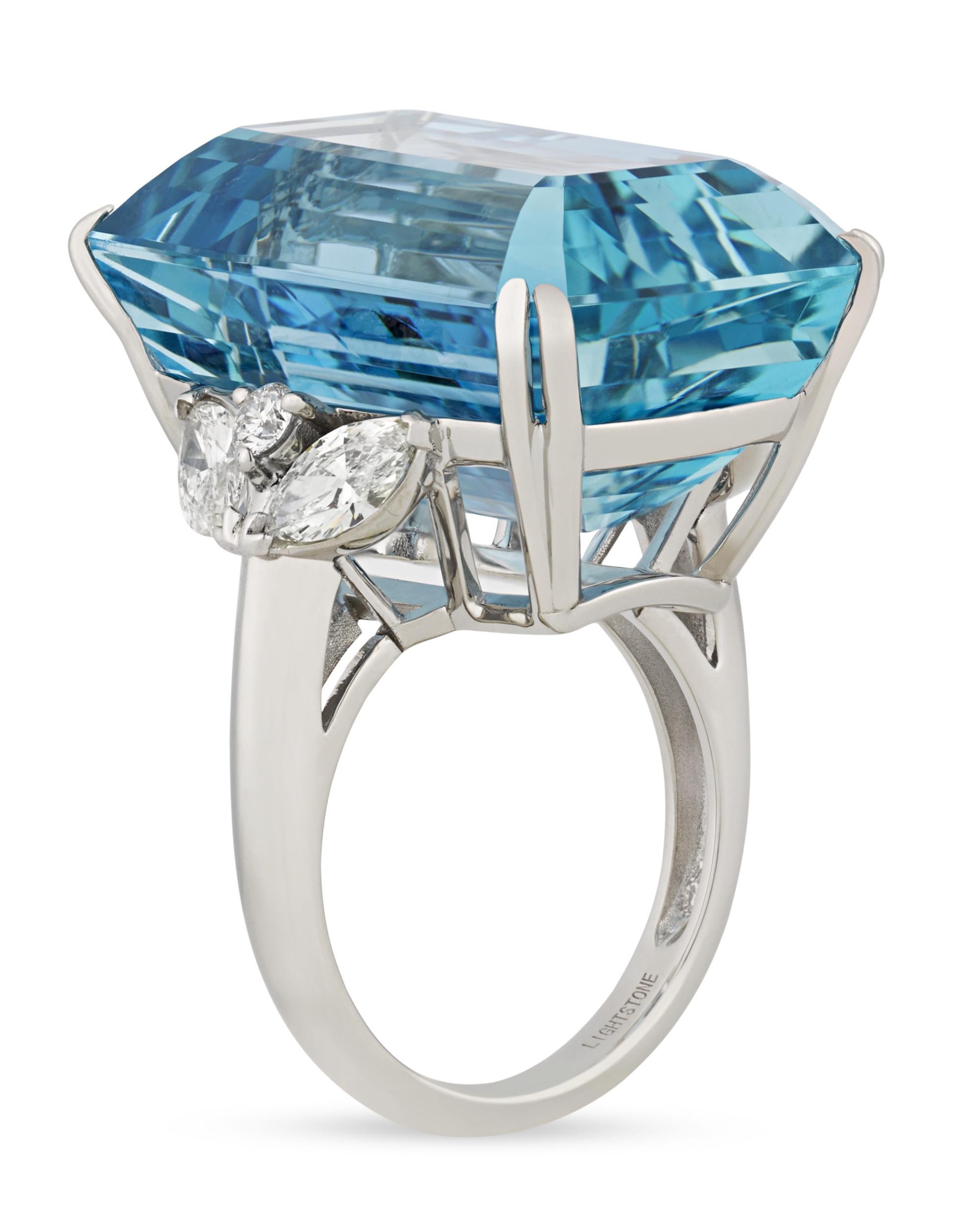With the stunning blue hue of a clear tropical ocean, the incredible 43.37-carat emerald-cut aquamarine at the center of this ring is absolutely captivating. This specimen possesses the deeply saturated Santa Maria blue hue that is found only in the