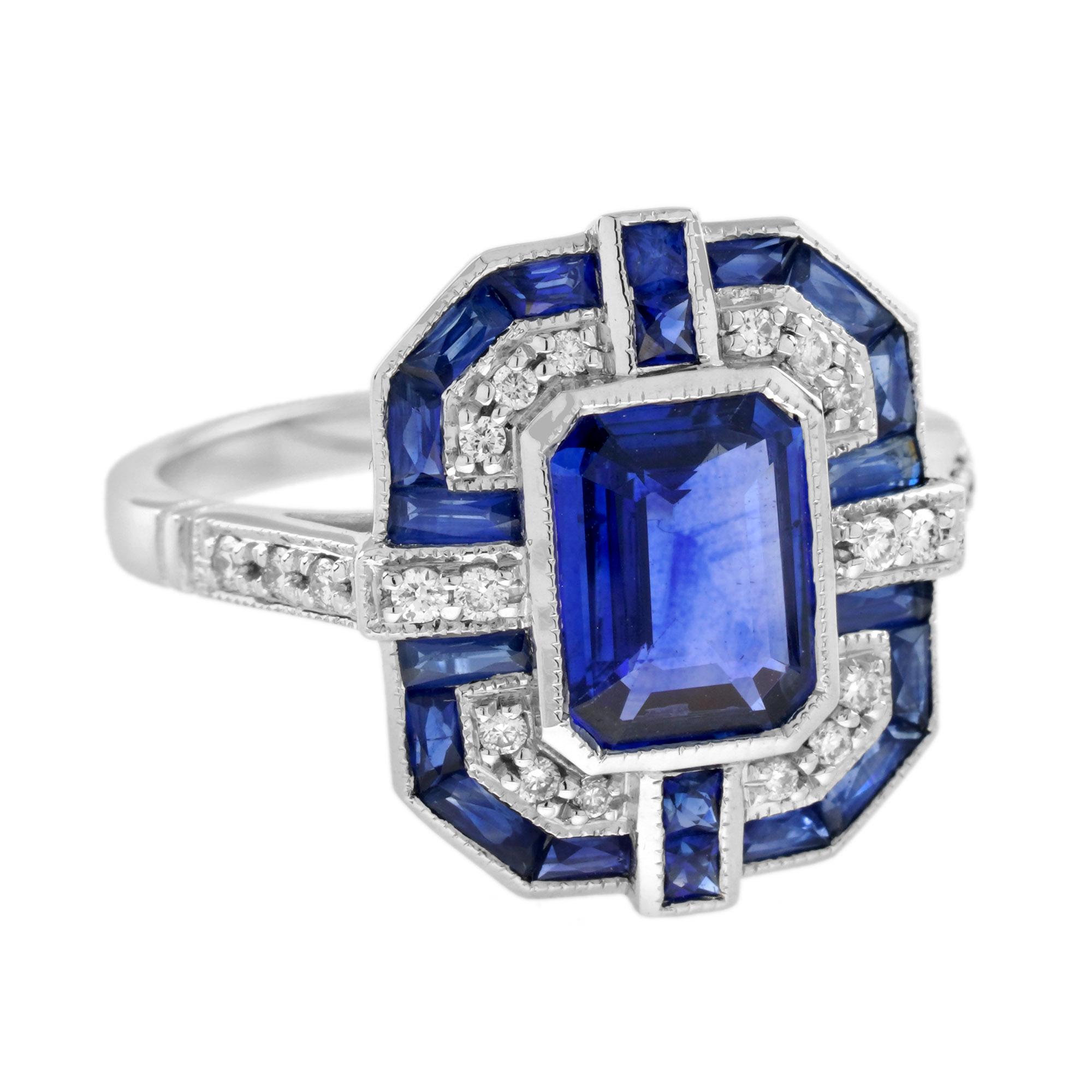 A striking and intriguing jewel, indeed. This bold Art Deco style ring highlights a gorgeous gleaming emerald cut Ceylon sapphire framed in eye-catching by French cut blue sapphires and white diamonds. Each side and shoulders set off with round