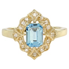 Bague de style vintage en or jaune 14 carats avec topaze bleue taille émeraude et halo de diamants