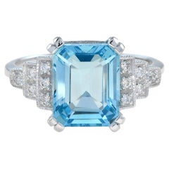 Bague de fiançailles en or 9K avec topaze bleue taille émeraude et diamant à l'épaulement