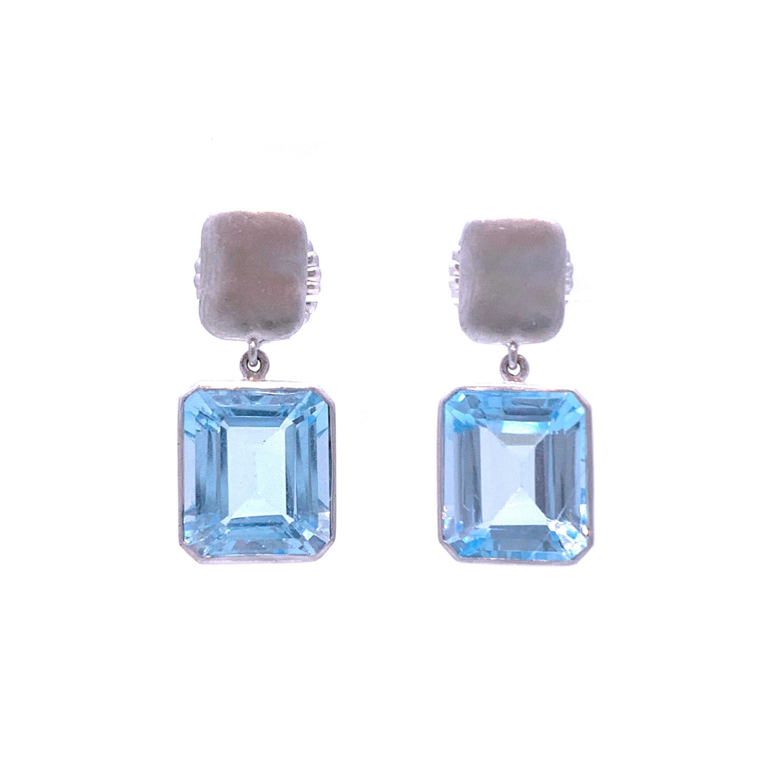 Bijoux Num Emerald-Cut Blue Topaz Drop Earrings

The earrings feature a pair of beautiful emerald-cut blue topaz, handset in platinum plated sterling silver, straight post back with large friction backs.  Top part is a unique in-house design with