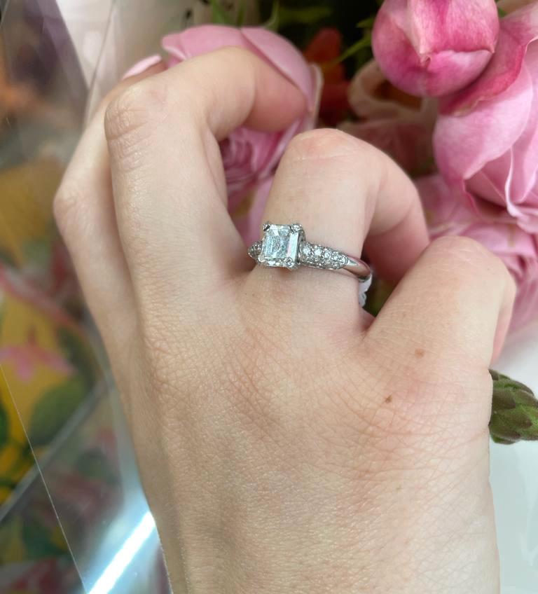 An emerald-cut diamond ring, set with an emerald-cut diamond, with and estimated weight of 1.23ct, with a colour range of I to J, VVS1 clarity, in a pavé set, four claw setting, with round brilliant-cut diamond pavé set shoulders, mounted in