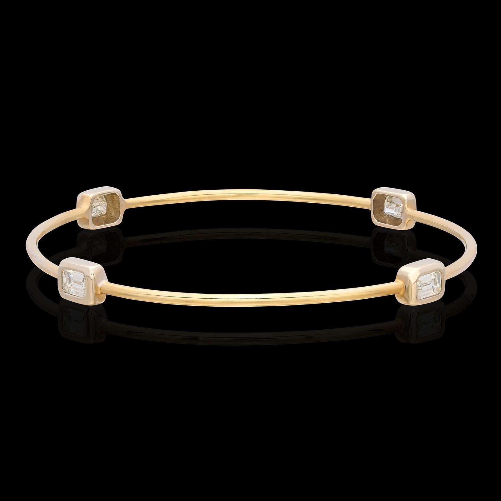This fun, stackable 18k bi-color gold bangle bracelet is a great addition to a collection. Designed with four emerald-cut diamonds set on the compass points, weighing together 1.58 carats, it's eye catching enough to wear on it's own, and also a