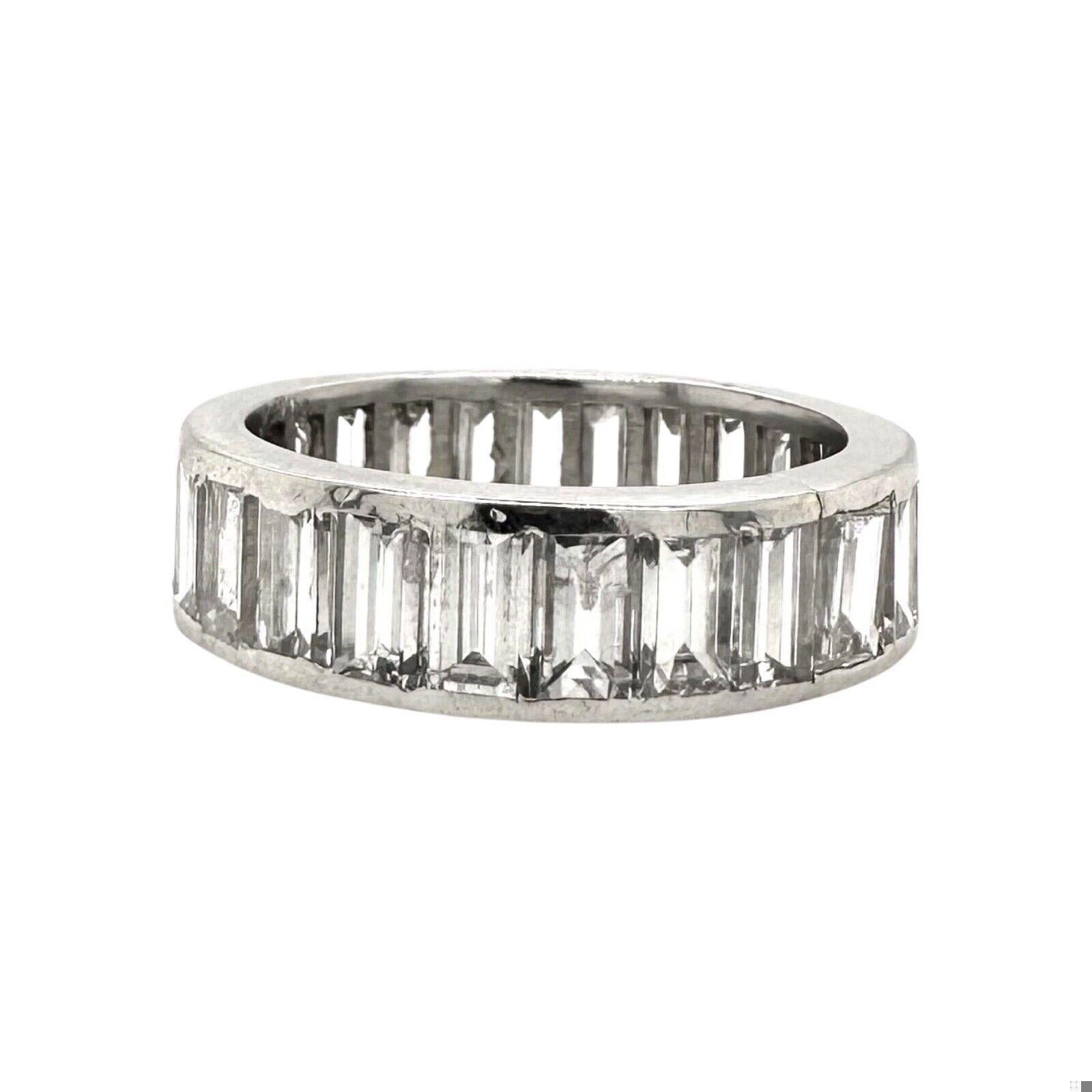 The 4 tcw Emerald cut Diamond Eternity Band in 950 platinum, size 6. An eternity band typically features a continuous line of gemstones around the entire circumference of the ring, symbolizing eternal love and commitment. The emerald-cut diamonds