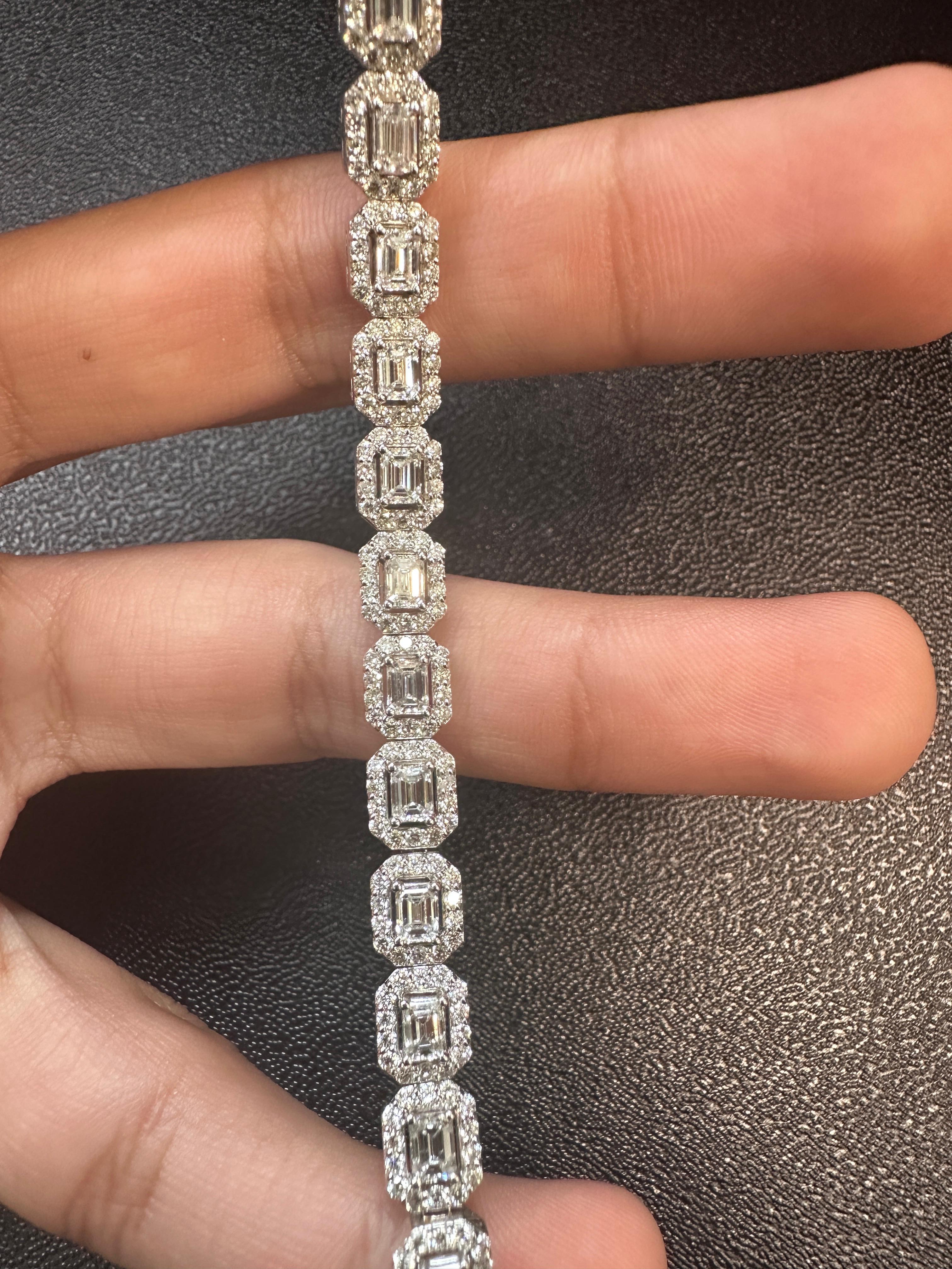 Questo elegante bracciale di diamanti sfoggia un design senza tempo realizzato in oro bianco 18 carati, con 23 diamanti taglio smeraldo, ciascuno splendidamente incorniciato da un'aureola di diamanti tondi taglio brillante. Con un peso totale di