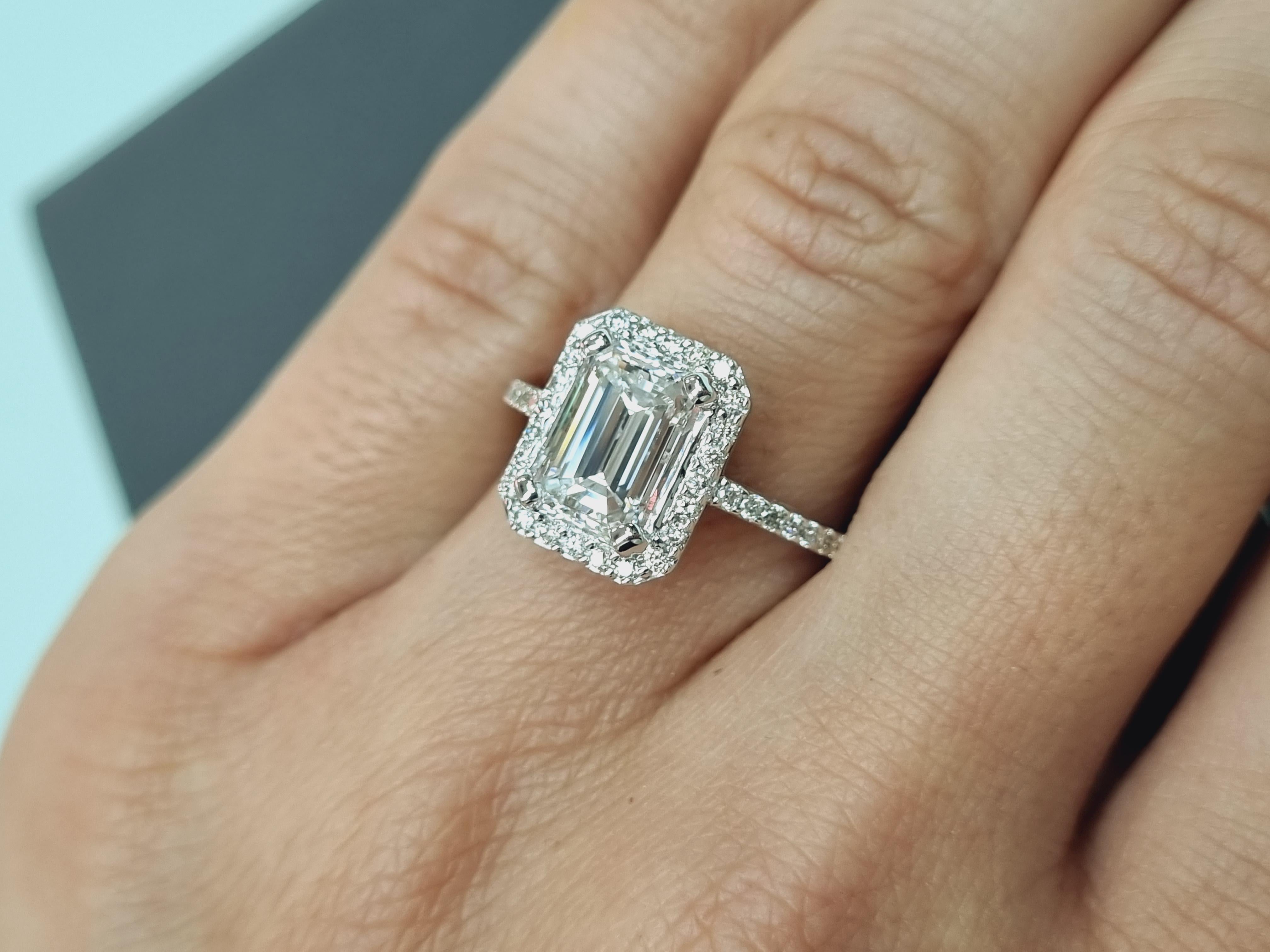 Introducing our exquisite 18k white gold Emerald Cut Diamond Halo Engagement Ring, a true embodiment of timeless elegance and sophistication. The focal point of this mesmerizing ring is a magnificent 2.08-carat emerald cut diamond, radiating