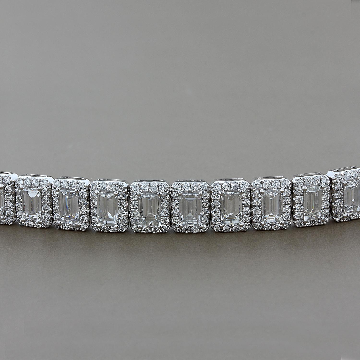This stunning bracelet features 17.54 carats of emerald cut diamonds haloed by 7.15 carats of round cut diamonds. Set in 18K white gold with a box clasp closure and two safety latches.  All diamonds are colorless VS quality.

Fits wrists up to 7