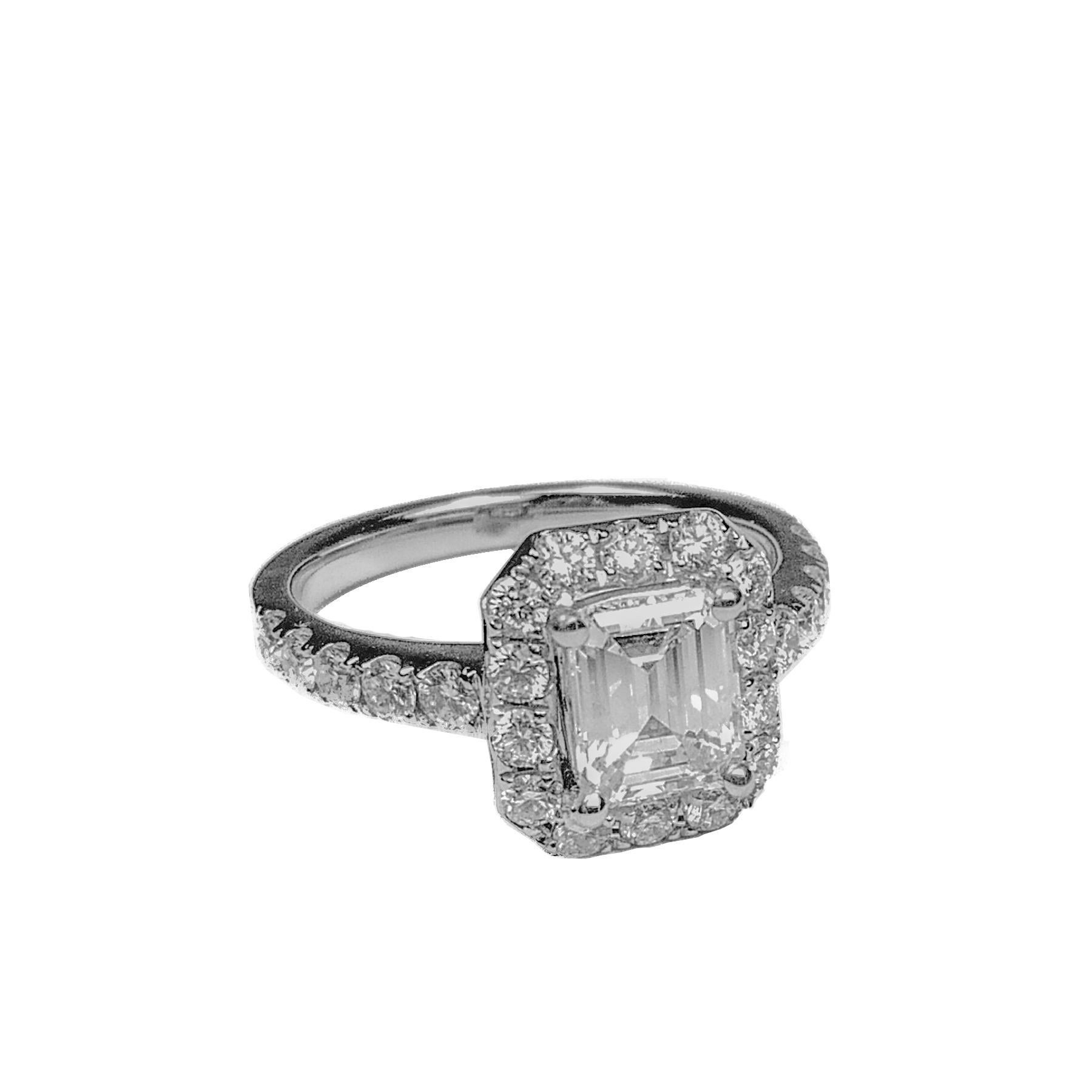 Emerald cut 1.01 carats diamond ring. Canadian diamond mounted in four prongs, framed with round brilliant cut diamonds, accented with diamonds on the band. Elegant handcrafted design set in 18 karat white gold.  Ideal for engagements and