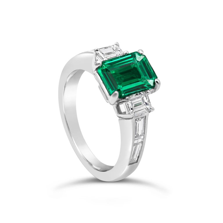 Showcasing a color-rich 1.66 carat green emerald. Two perfectly matched emerald diamonds elegantly flank the center diamond for a very classy and sophisticated piece. Additional four emerald cut diamonds channel set on an 18 karat white gold