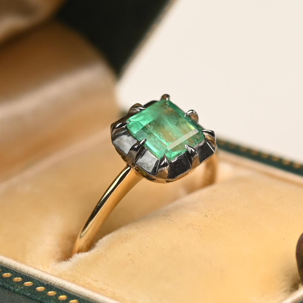 Dieser auffällige Ring präsentiert einen Smaragd von ca. 1,00 Karat im Smaragdschliff, der in einer geschwärzten Platin-Zackenfassung gefasst ist, die den satten, grünen Farbton des Edelsteins hervorhebt. Die Untergalerie ist mit einem eleganten