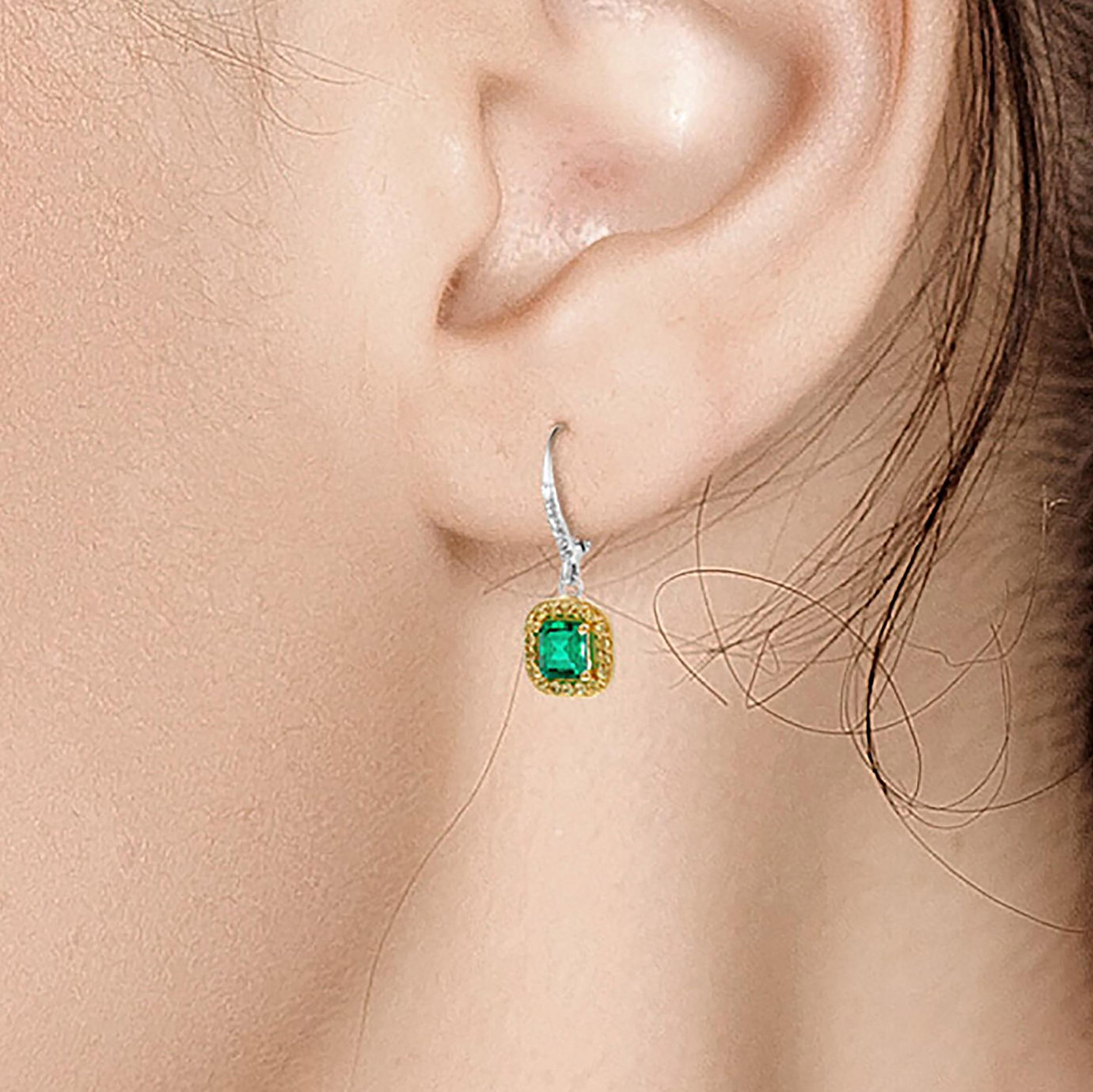 Fourteen karats white gold hoop cluster earrings 
Two Emerald cut emerald weighing 1.85 carat 
Diamonds weighing 0.24
Yellow Sapphire weighing 0.40 carat
Earrings measuring 1.5-