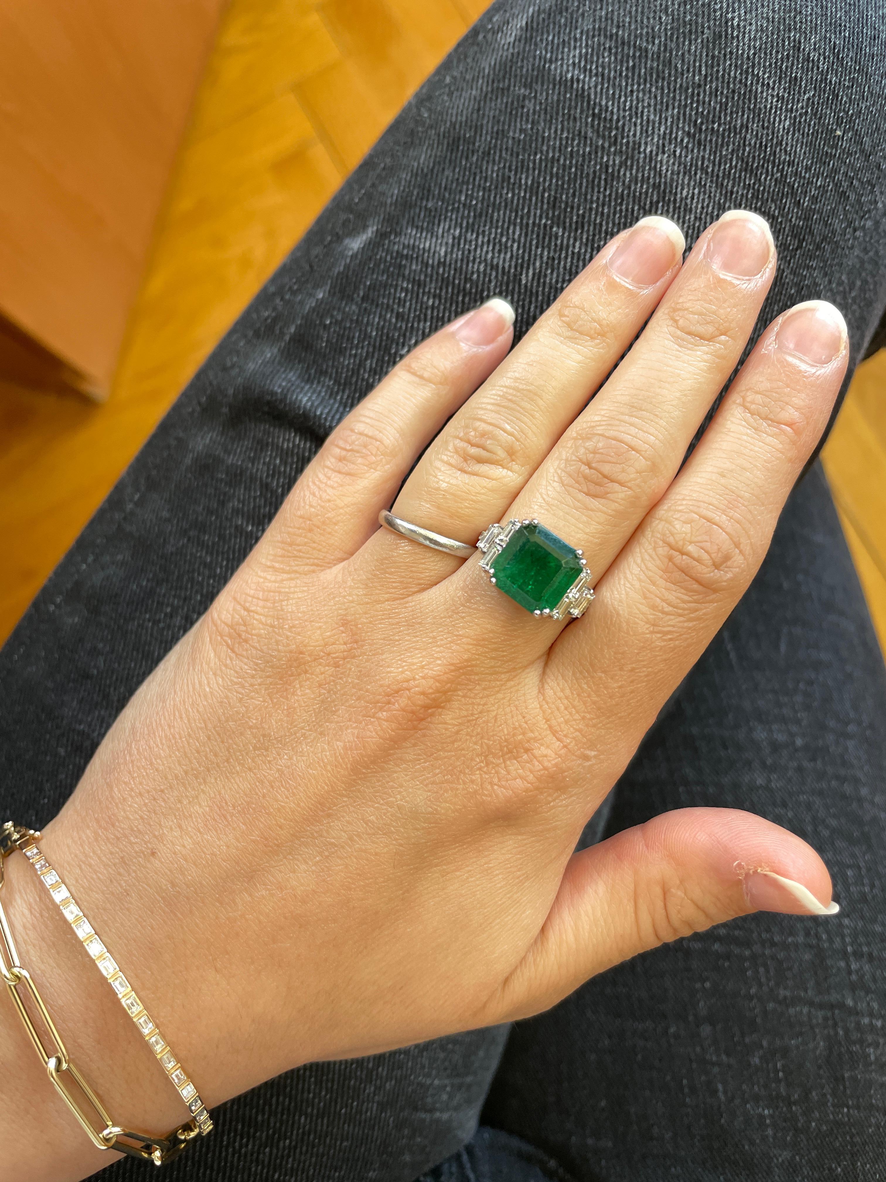 Material: 18K White Gold
Center Stone Details: 1 Emerald Cut Emerald at 5.40 Carats - Measuring 10.6 x 10.5 x 7.2 millimeters
Side Stone Details: 12 Round Brilliant White Diamonds at 0.15 Carats Total Weight Color: H-I / Clarity: SI
6 White Baguette