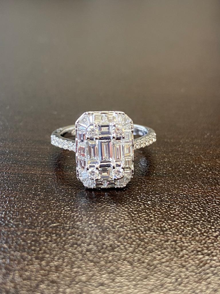 18K Ring set with cluster of baguette and round diamonds in an engagement ring style setting to create the illusion of a single emerald cut look. The ring weighs 2.63 carats, the color is F, the clarity is VS1-VS2. The ring is a size 7.